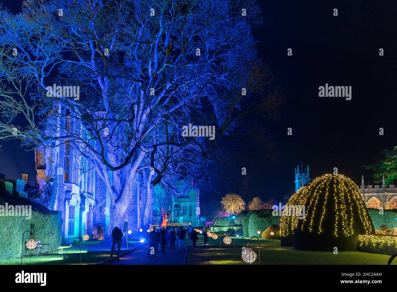 Winchcombe, Großbritannien. 22. Dezember 2021. Die Gebäude und das Gelände von Schloss Sudeley leuchten während des diesjährigen Spektakels „Spectacle of Light“ mit Farbe. Das mittlerweile sechste Jahr nach Einbruch der Dunkelheit umfasst einen beleuchteten Pfad rund um das Gelände und den Wald von Sudeley, glitzernde Wasserspielen und einen einzigartigen „Teppich aus Farbe“. Quelle: Carl Hewlett/Alamy Live News Stockfoto