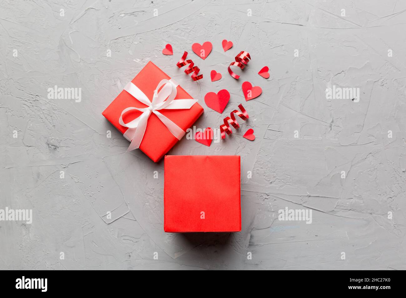 Happy Valentinstag geöffnete herzförmige Geschenkbox mit kleinen Herzen, auf farbigem Hintergrund, Valentinskarte - Draufsicht Konzept. Stockfoto
