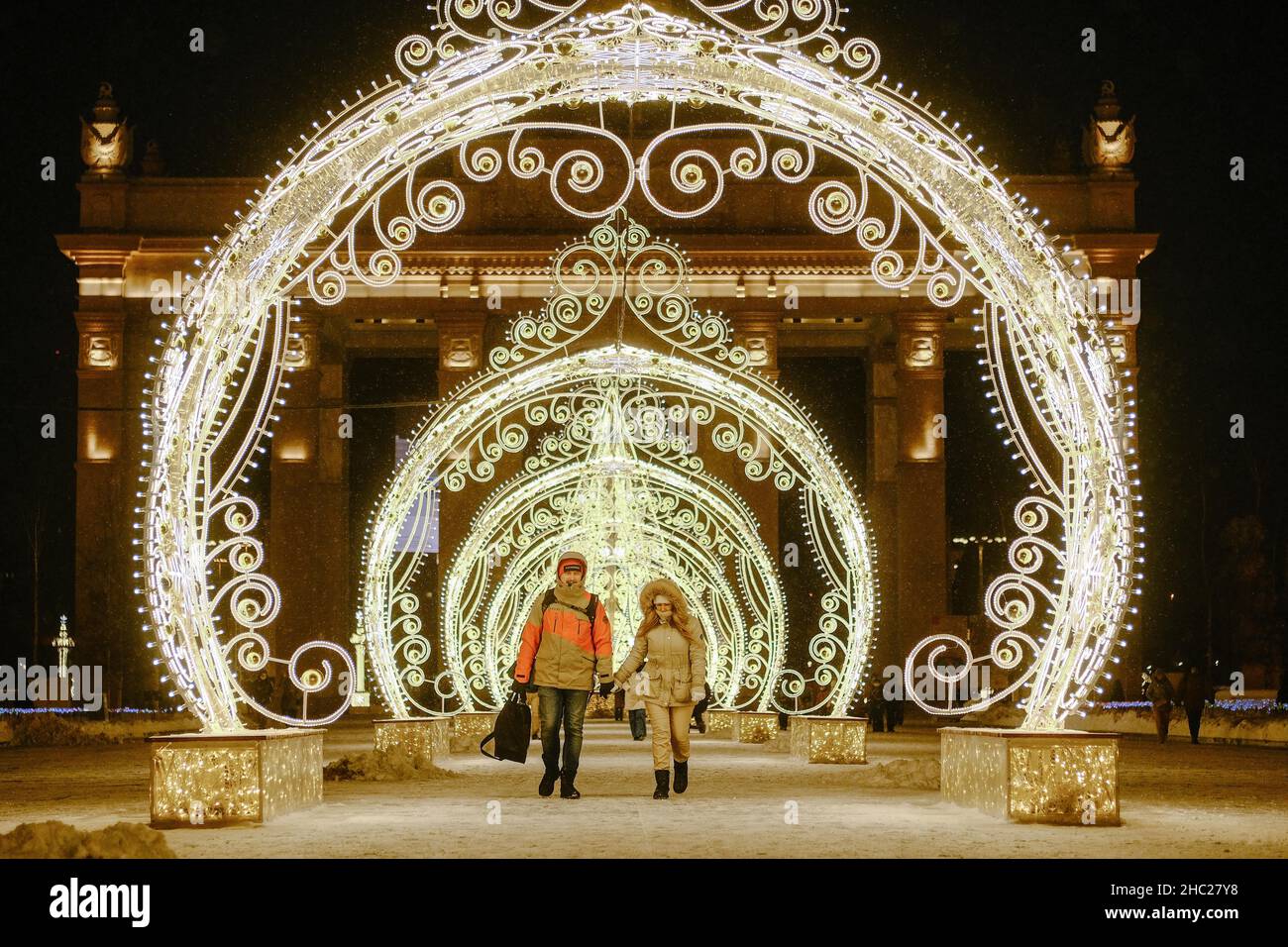 (211221) -- MOSKAU, 21. Dezember 2021 (Xinhua) -- Menschen gehen am 21. Dezember 2021 in der VDNH (Ausstellung der Errungenschaften der Volkswirtschaft) in Moskau, Russland, durch die Neujahrsdekorationen. (Xinhua/Evgeny Sinitsyn) Stockfoto