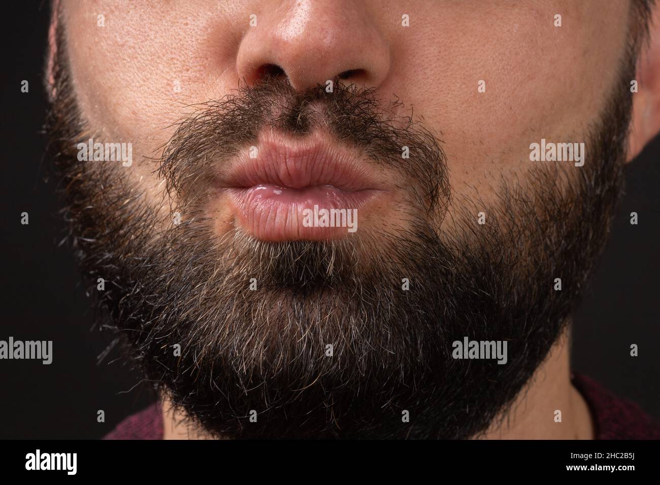 Close - up Ovely stattlichen Kerl flirtet mit Mädchen weht Kuss. Unrasierte Mann mit attraktivem Aussehen zeigt Freundin Sympathie gehen zu küssen Stockfoto