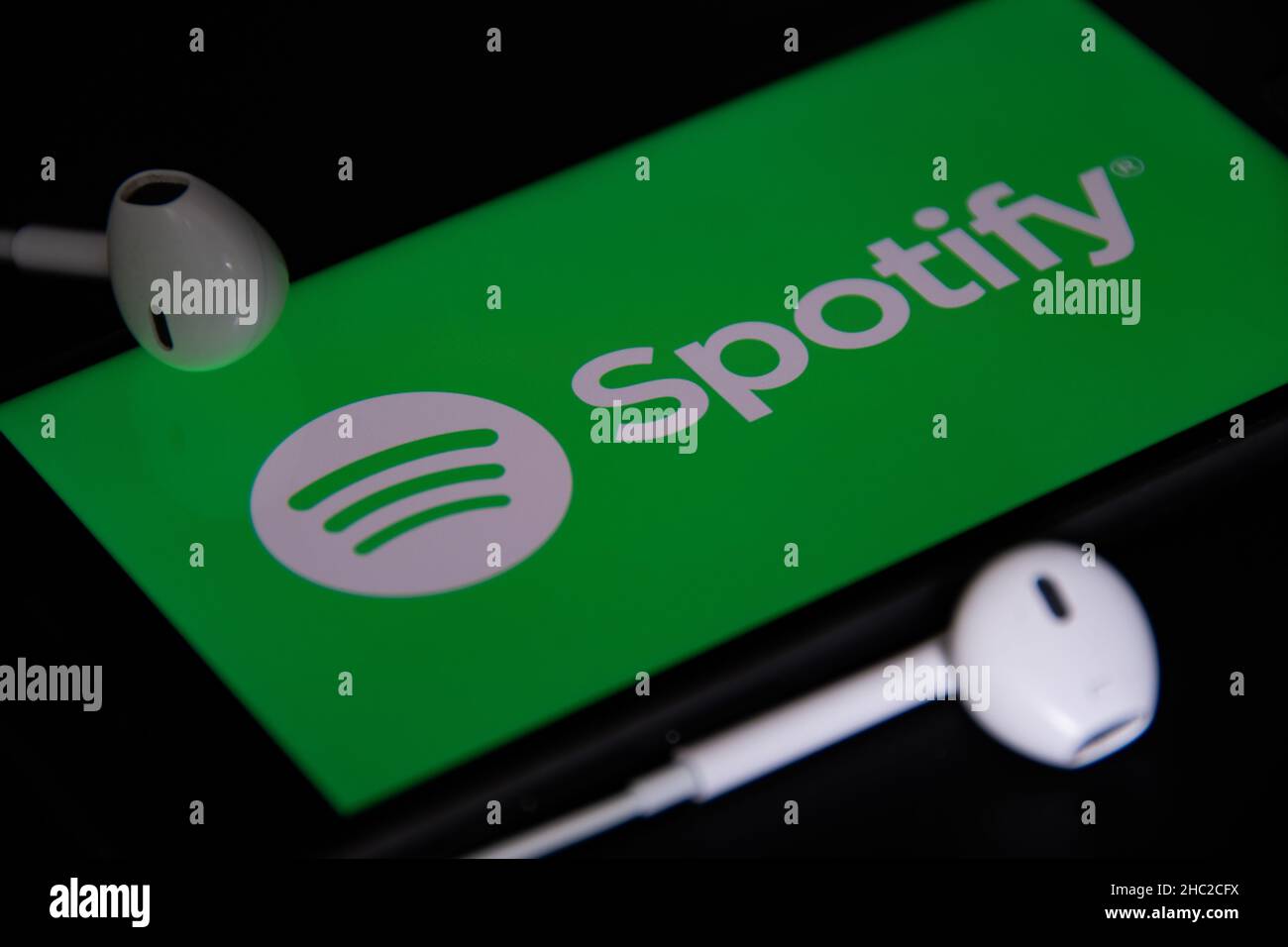 Rheinbach, Deutschland 4. Mai 2021, Nahaufnahme des „Spotify“-Logos auf dem Bildschirm eines Smartphones mit Kopfhörern Stockfoto