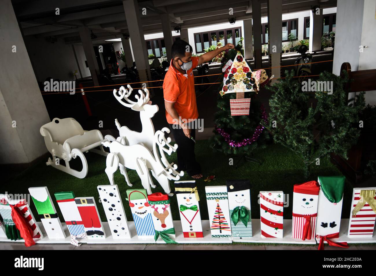 (211223) -- SOUTH TANGERANG, 23. Dezember 2021 (Xinhua) -- Ein Arbeiter richtet einen Weihnachtsbaum in der katholischen Kirche Saint Barnabas in South Tangerang, Provinz Banten, Indonesien, am 23. Dezember 2021 ein. (Xinhua/Agung Kuncahya B.) Stockfoto