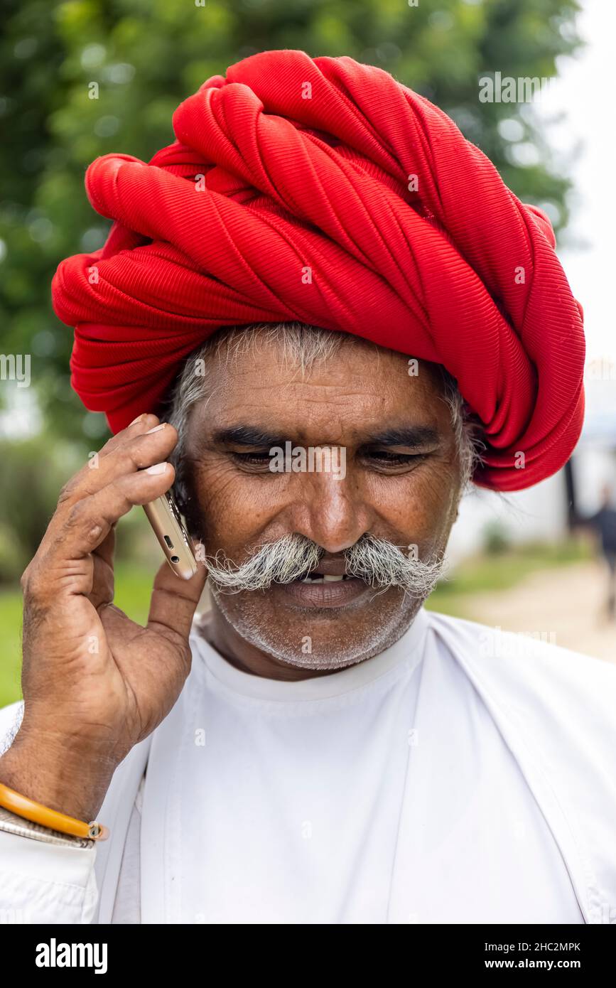 JAWAI, Rajasthan, Indien - September 2021: Porträt eines älteren Mannes der ethnischen Gruppe der Rabari in einem nationalen Kopfschmuck und einem traditionellen weißen Kleid. Stockfoto