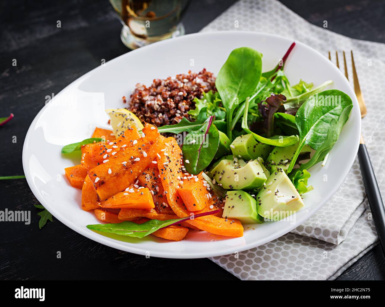 Vegane Mahlzeiten, Mittagessen. Buddha-Schale mit Quinoa, gebratenem Kürbis, Avocado und grünen Kräutern. Vegetarische, gesunde Ernährung Konzept. Stockfoto