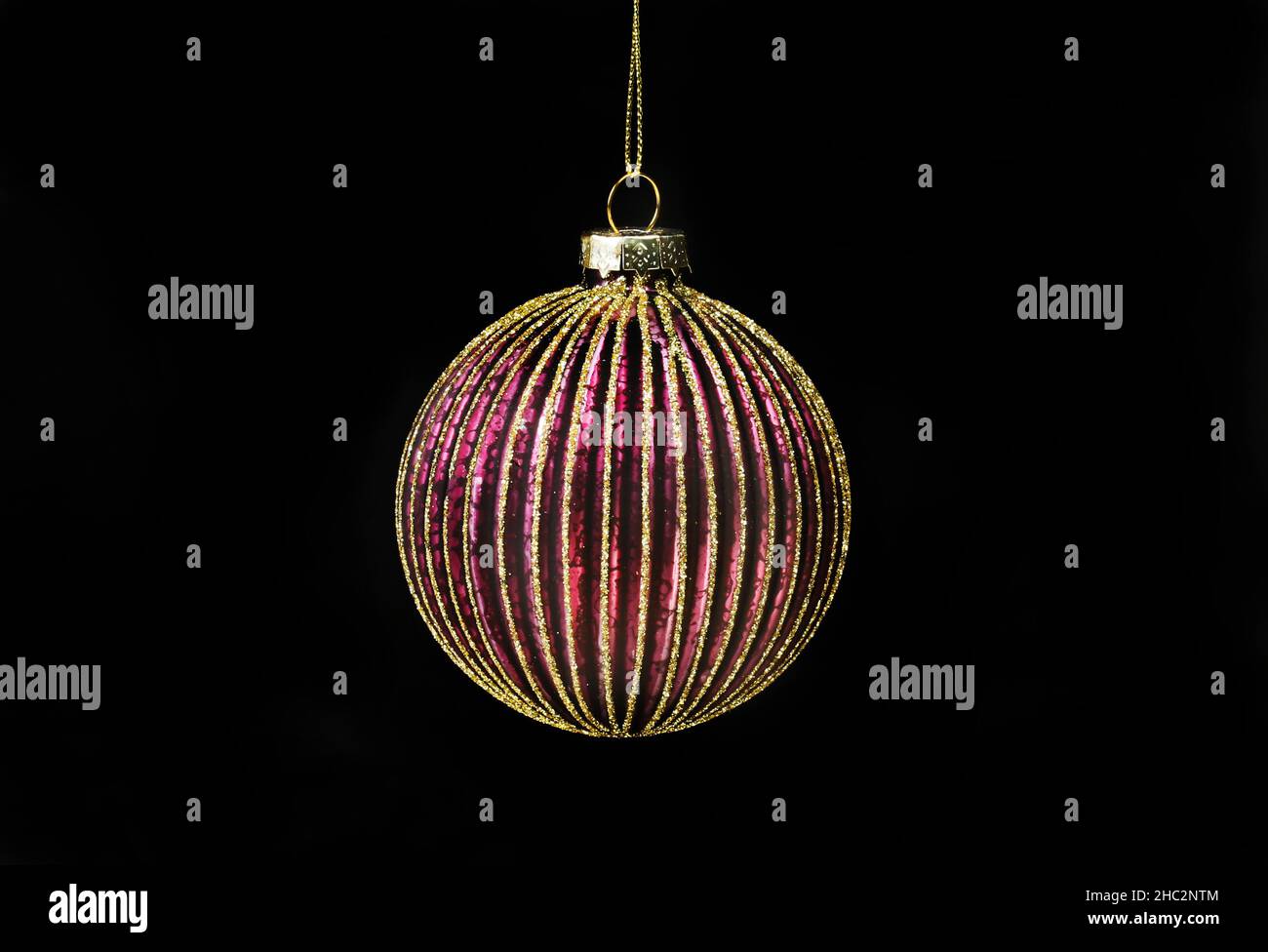 Rote und goldene Glitzerkugel isoliert gegen Schwarz Stockfoto