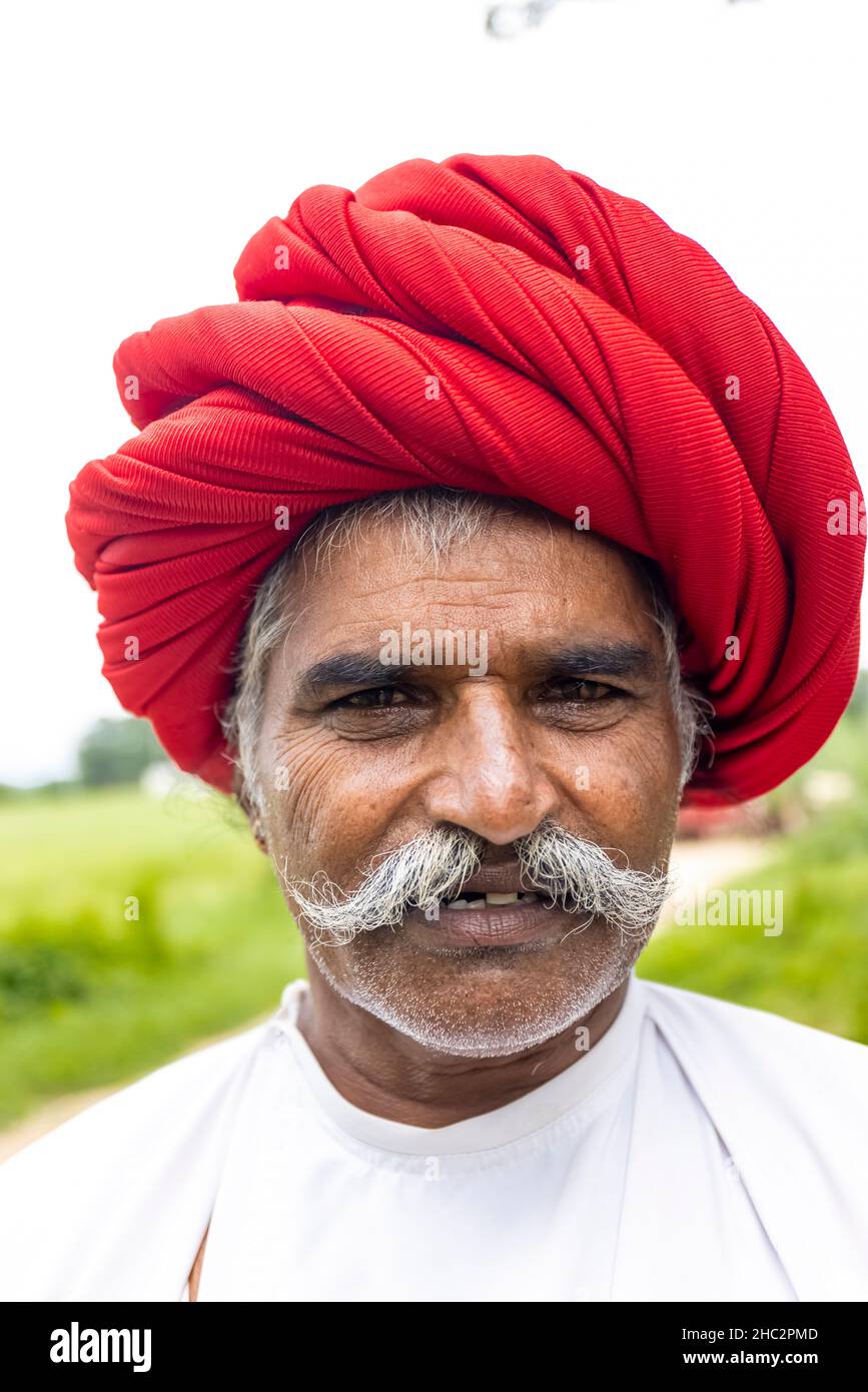 JAWAI, Rajasthan, Indien - September 2021: Porträt eines älteren Mannes der ethnischen Gruppe der Rabari in einem nationalen Kopfschmuck und einem traditionellen weißen Kleid. Stockfoto