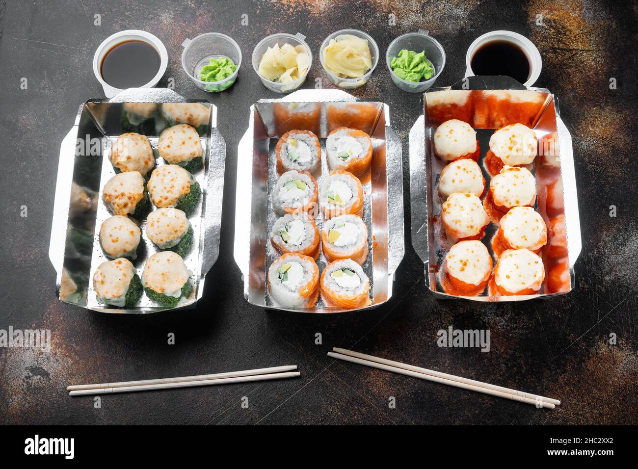 Sushi-Rollen im Take-away-Container-Set, auf altem dunklen, rustikalen Hintergrund Stockfoto