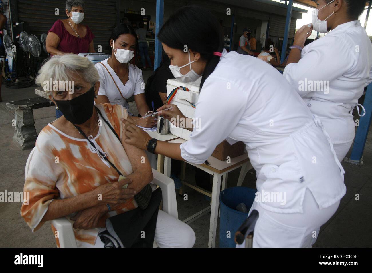 San Francisco, Venezuela. 23rd Dez 2021. Venezolanisches medizinisches Personal übergibt die zweite Dosis des Impfstoffs gegen Covid-19 an eine große Anzahl von Menschen am Donnerstag, den 23. Dezember 2021, in der Stadt San Francisco, Venezuela. Nach der Ankündigung von Präsident Nicolás Maduro berichtete er, dass die omicron-Variante in Venezuela eintraf, sieben Fälle wurden entdeckt. Die Auffrischimpfung wird im Januar beginnen und präzisiert, dass die dritte Dosis ab dem 3. Januar 2022 verteilt werden soll. (Foto von Humberto Matheus/Sipa USA) Quelle: SIPA USA/Alamy Live News Stockfoto