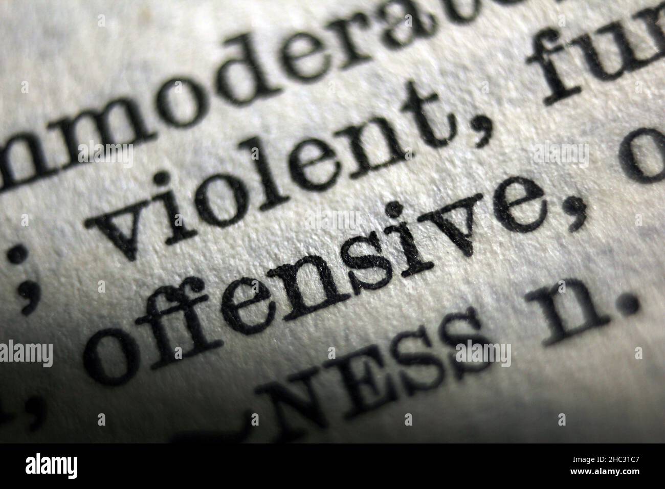 Wort „anstößig“ und „gewalttätig“ auf Wörterbuchseite, Makroaufnahme Stockfoto