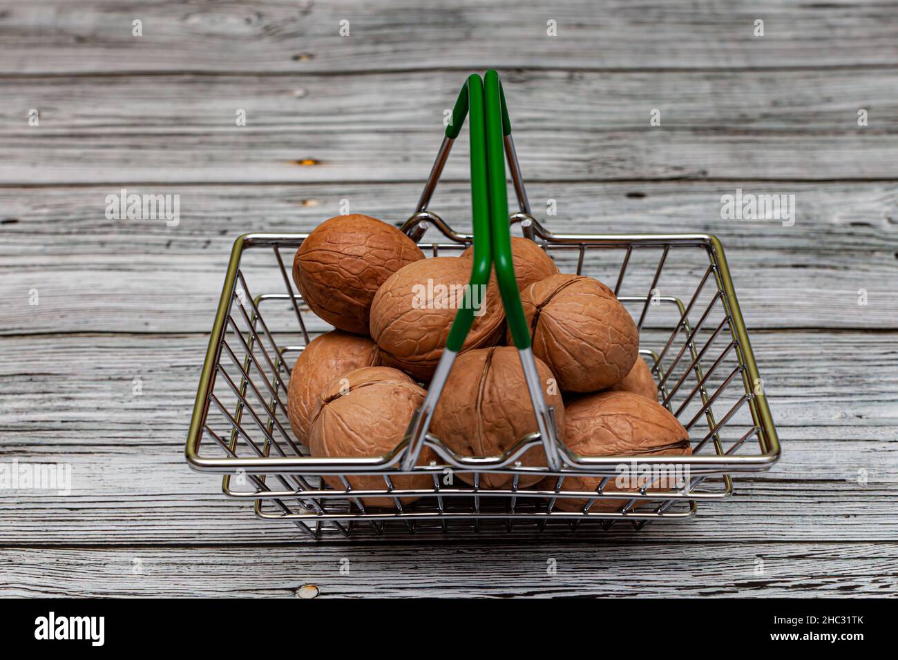 Walnussfrüchte liegen in einem kleinen Eisenkorb. Hochwertige Fotos Stockfoto