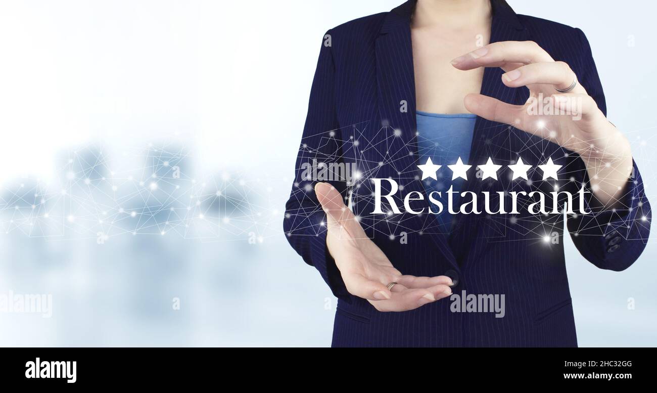 Bewertung, Bewertung, Zufriedenheit. Zwei Hand halten virtuelle holographische fünf-Sterne-Symbol mit Text Restaurant auf hellem unscharfen Hintergrund. Stockfoto