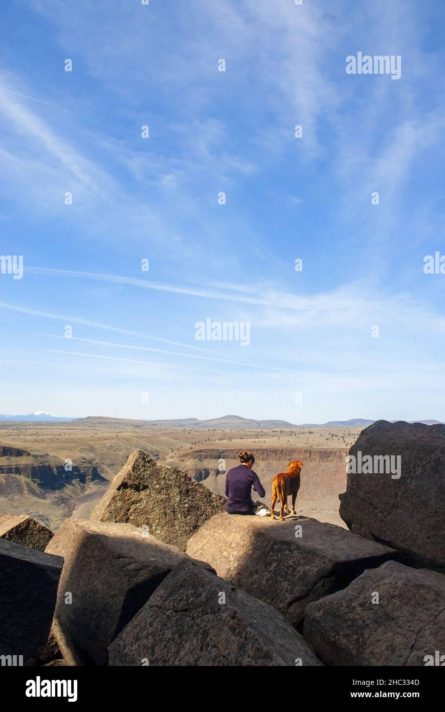 Alleinerziehende Frau mit Hund bereitet euch auf den Felsklettern vor. Forelle Creek, Oregon Stockfoto