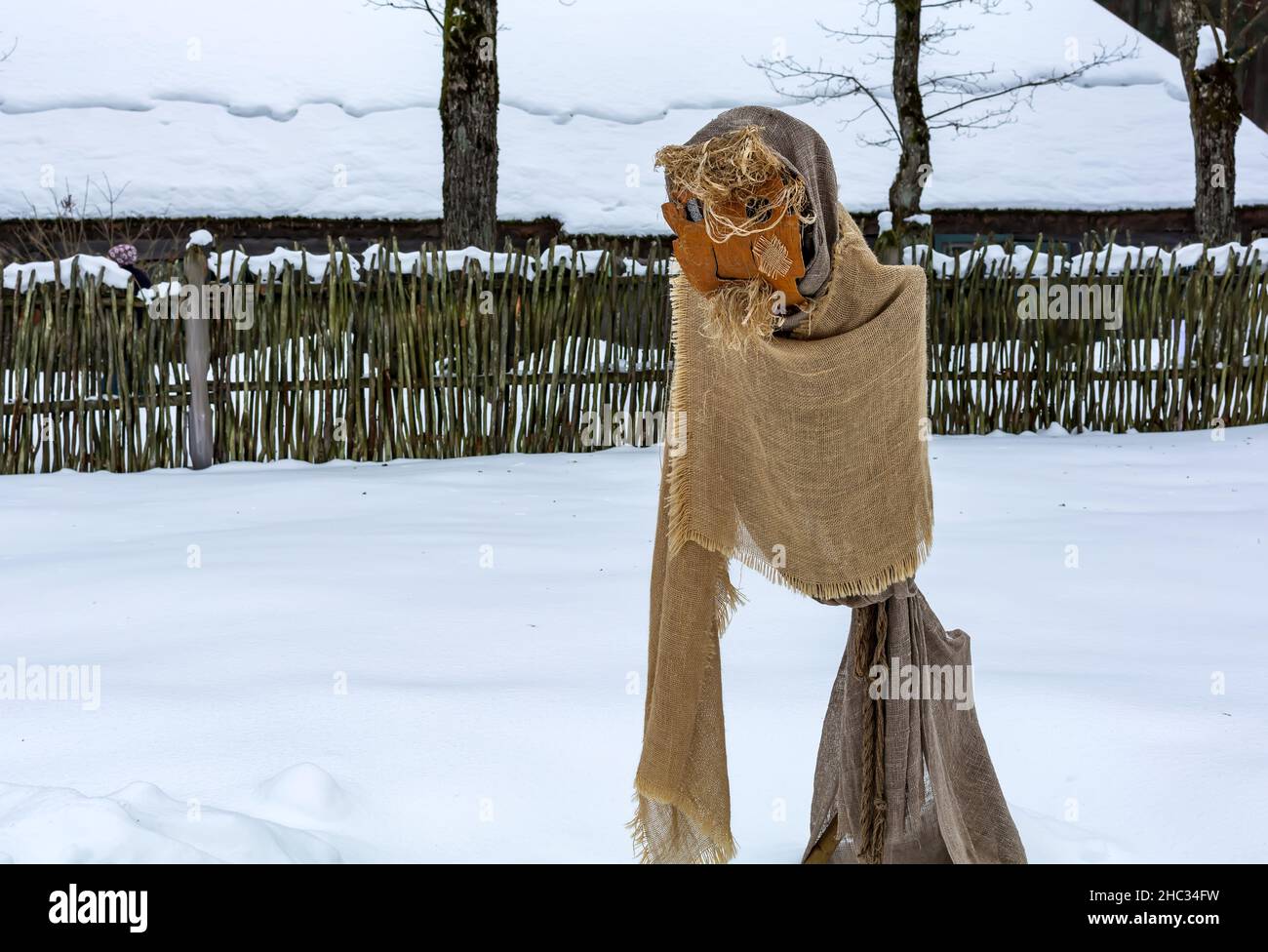 Puppe der Kreatur mit Bart in Meteņi Mumming Maske und Kostüm Aufenthalt im verschneiten Hof Stockfoto