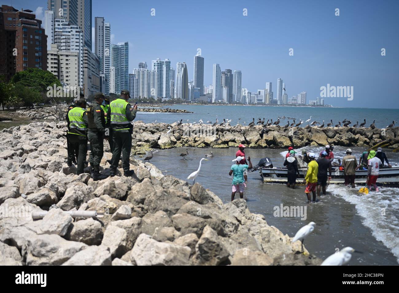 Polizisten beobachten Fischer, die am Strand von Bocagrande in Cartagena de Indias, Kolumbien, arbeiten Stockfoto