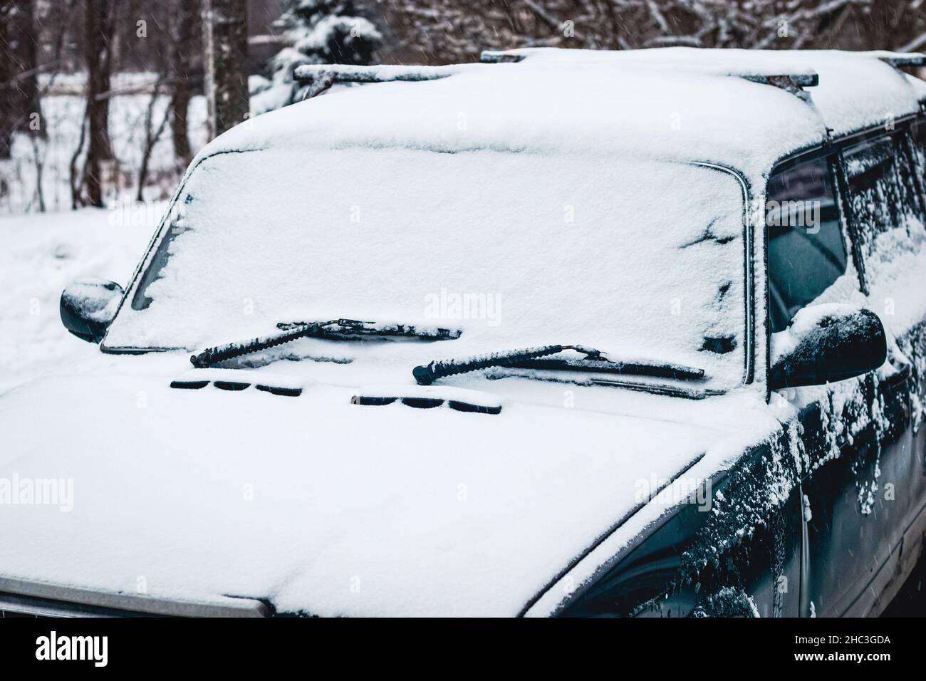 Altes Auto mit Schnee bedeckt, Fahren in verschneitem Wetter Stockfoto