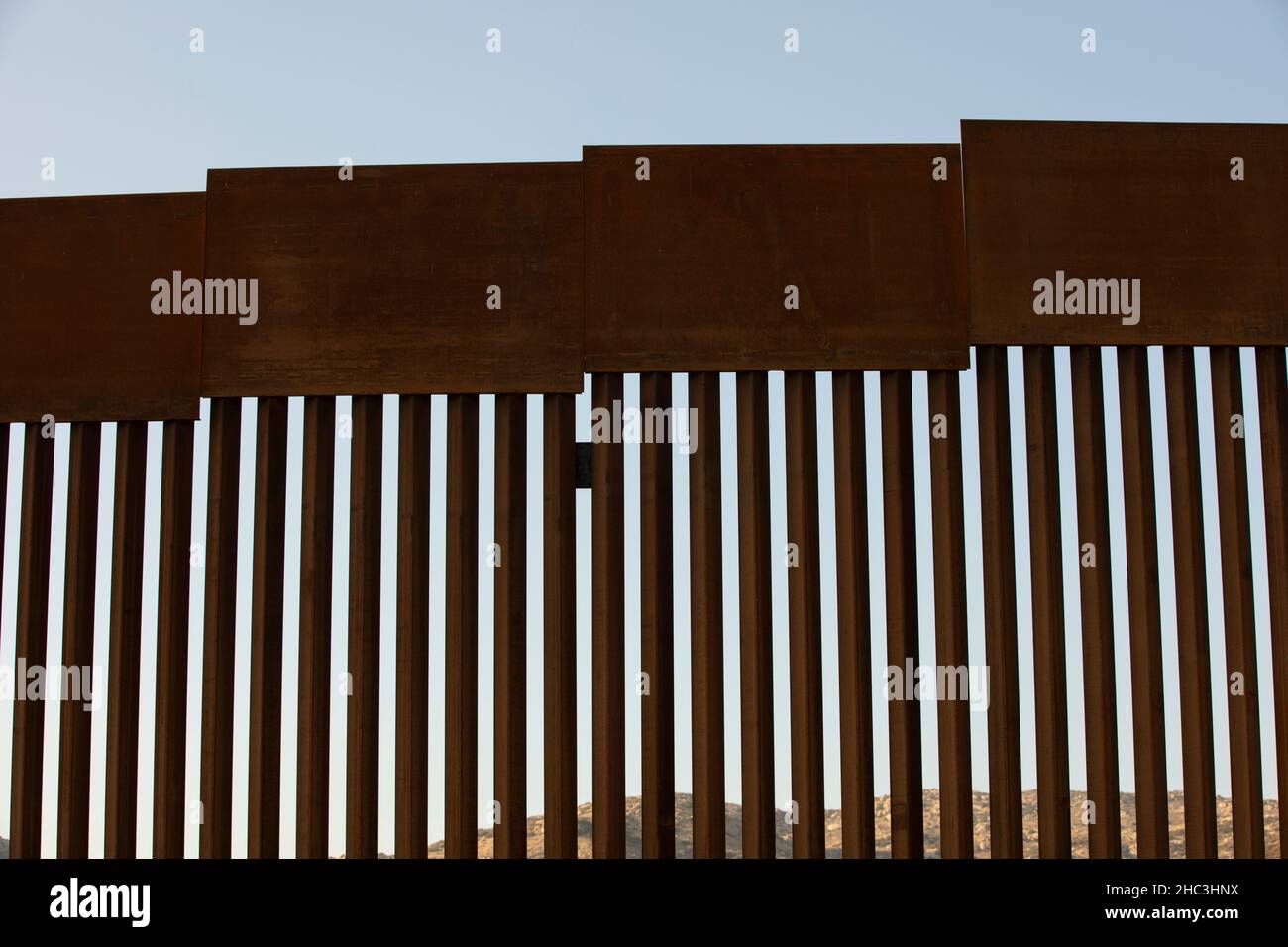 Am Nachmittag scheint der Sonnenuntergang an der Grenzmauer zwischen den USA und Mexiko in der Innenstadt von Tecate, Baja, Mexiko. Stockfoto