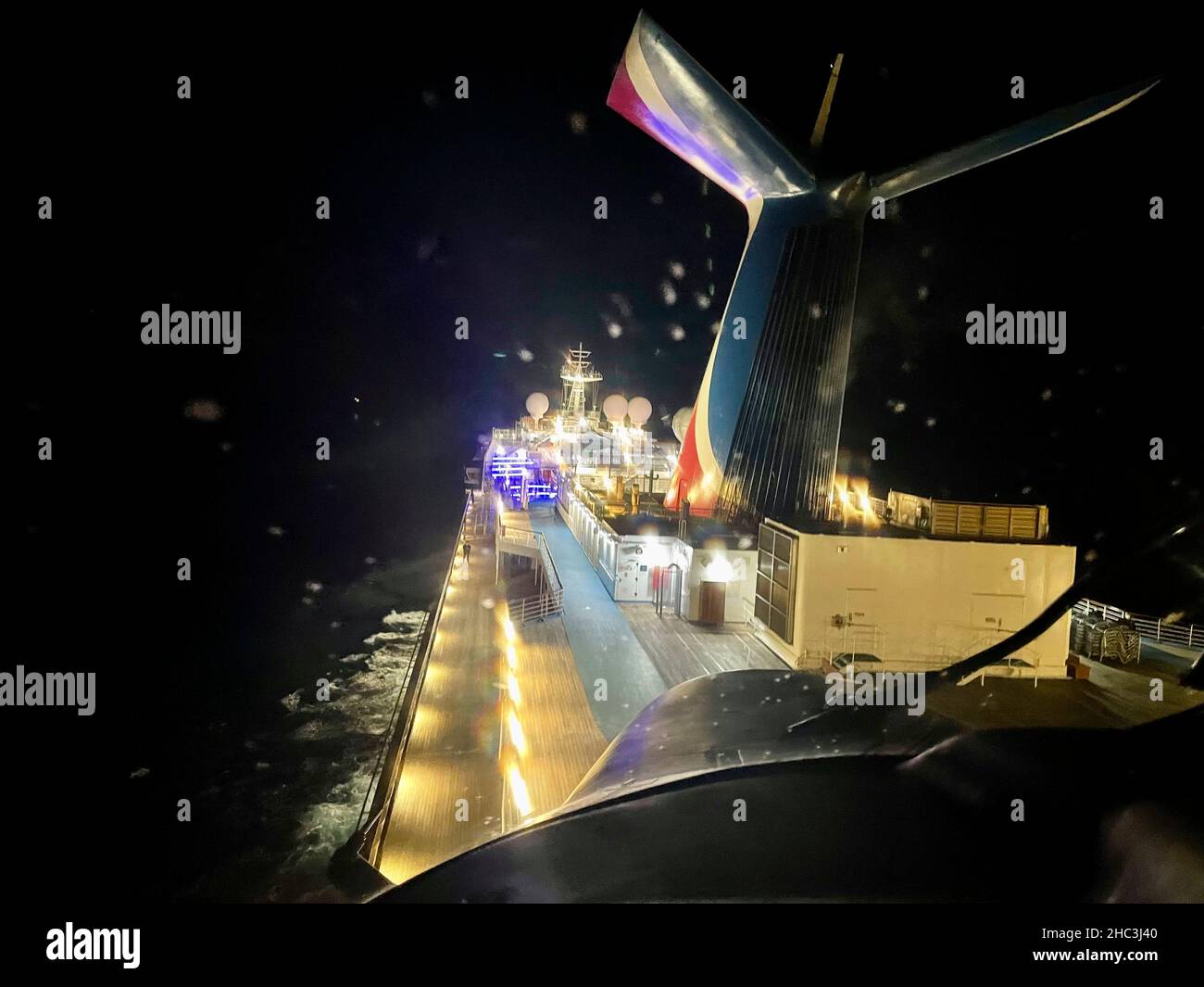 Eine Küstenwache-Luftstation New Orleans MH-65 die Dolphin-Besatzung medevacs einen Kreuzfahrtpassagier an Bord von Carnival Valor 218 Meilen südlich von Southwest Pass, Louisiana am 22. Dezember 2021. Der Mann wurde in das Universitätsklinikum verlegt und berichtete zuletzt, dass er sich in einem stabilen Zustand befand. (USA Foto der Küstenwache) Stockfoto