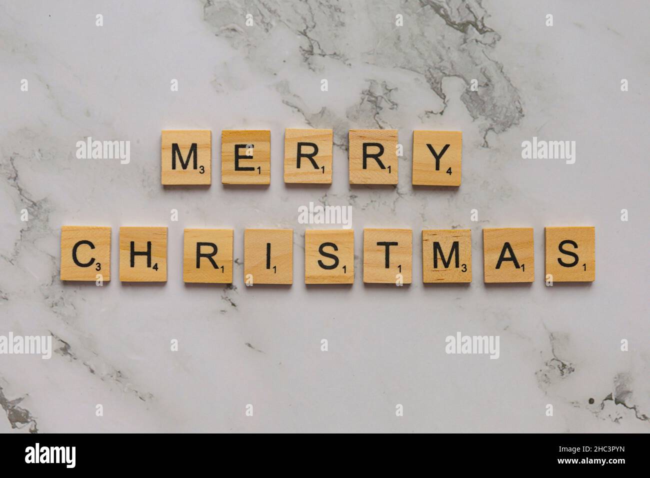 Beschriftende Holzfliesen bilden die Worte Frohe Weihnachten Stockfoto