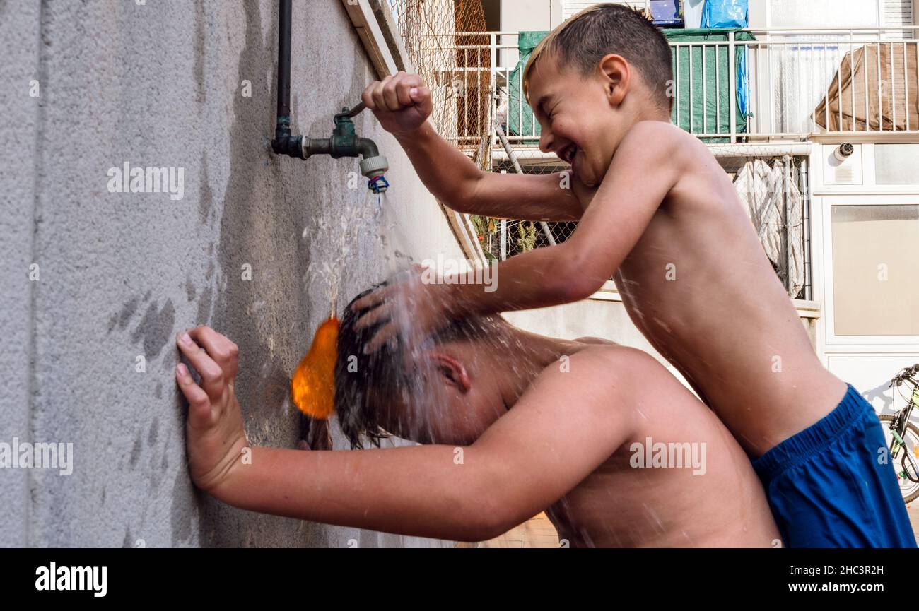 Kinder, die an einem schönen Sommertag mit Wasser spielen, stehen im Fokus Stockfoto