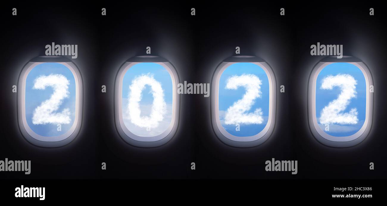Wolke 2022 vor dem Flugzeugfenster öffnen vier Flugzeugfenster einen weißen Fensterverschluss mit blauem Himmel und einer weißen Wolke in Form von 2022 Stockfoto