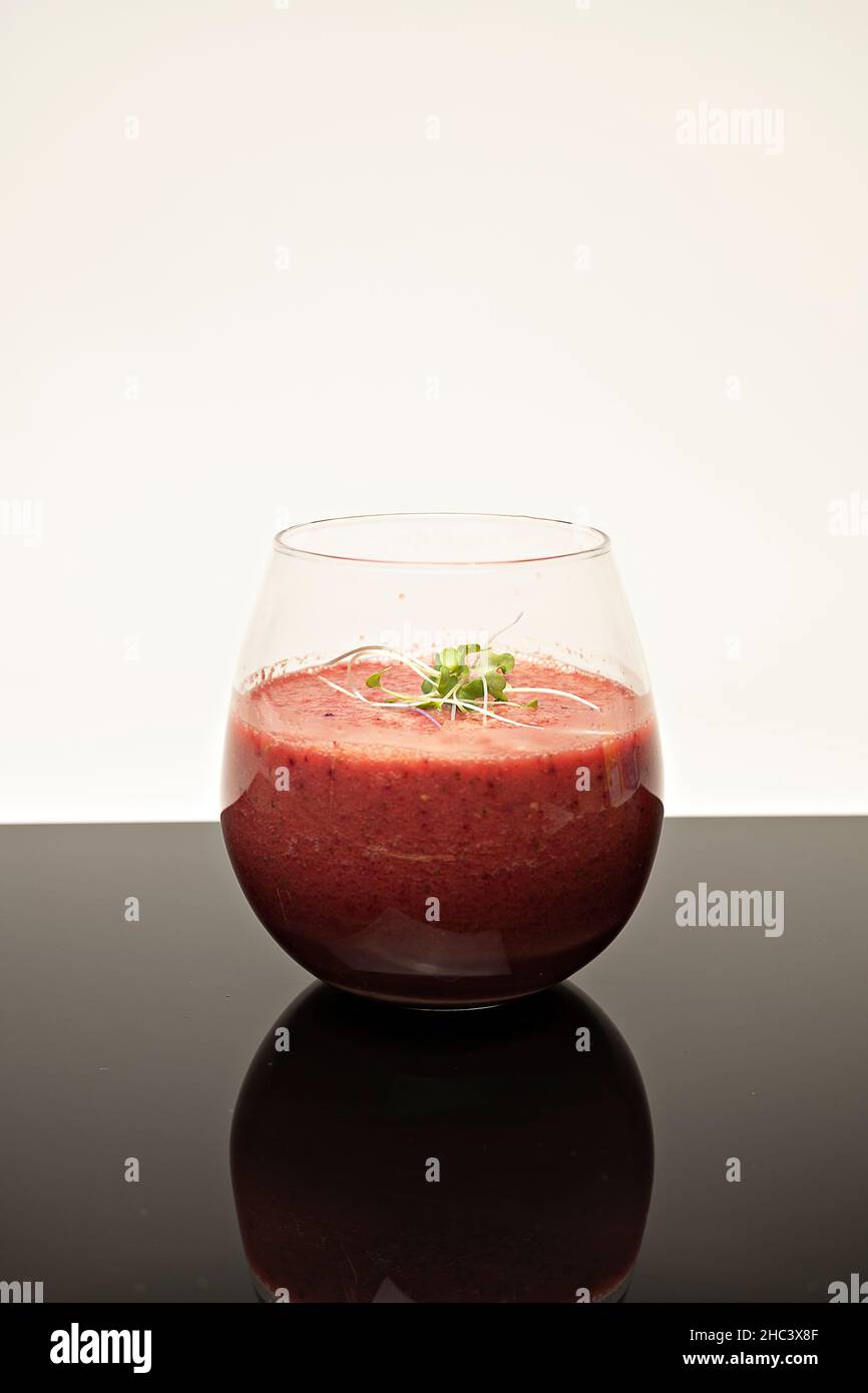 Vertikale Aufnahme eines Glases Fruchtmoothie auf dem Tisch Stockfoto