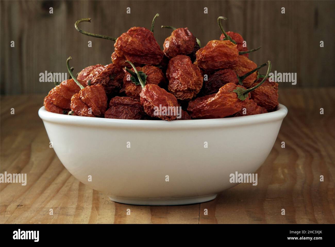 Mini-Paprika in einer Schüssel auf einem hölzernen Hintergrund Stockfoto