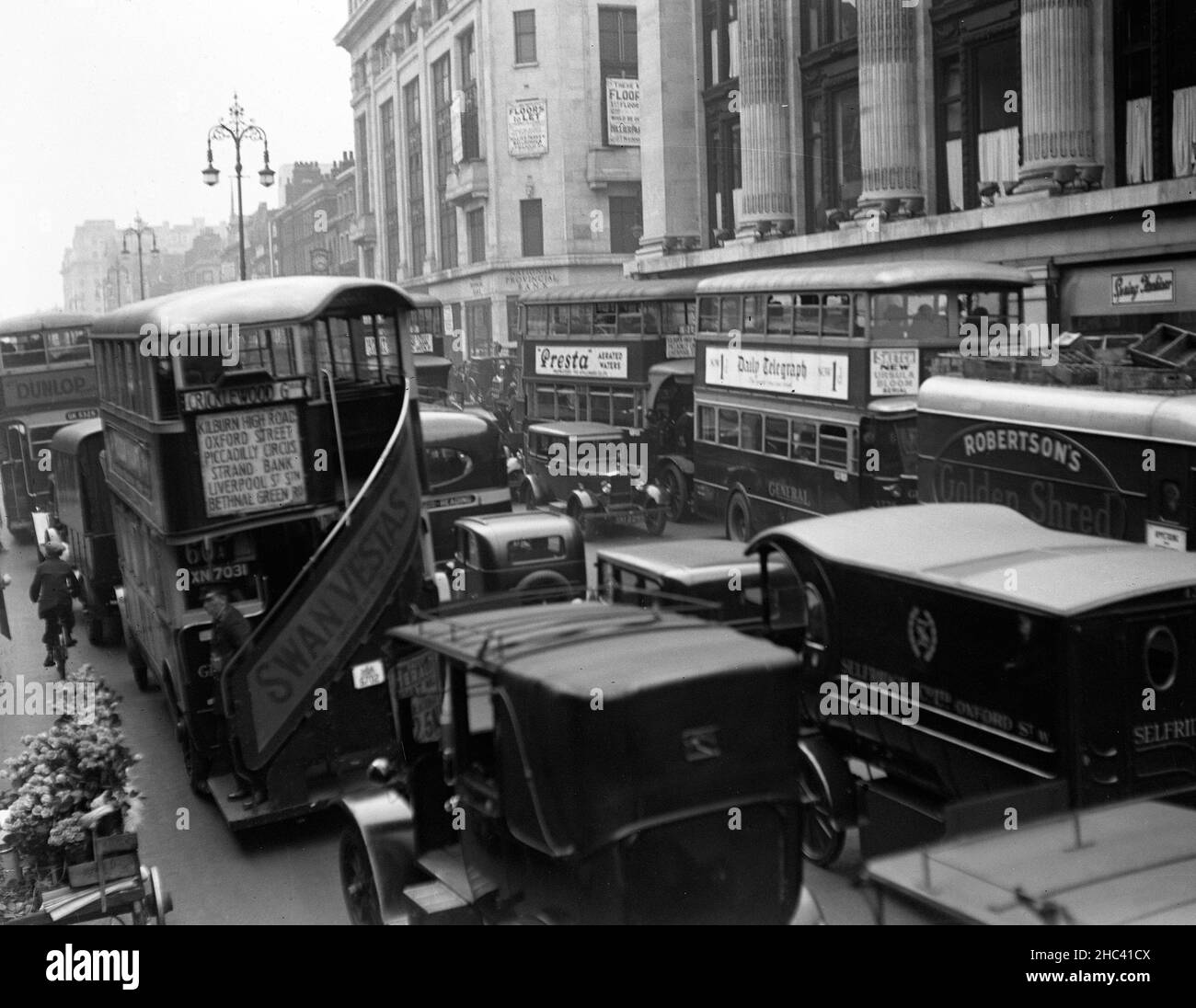 Das Foto der Akte datiert 1931 vom Verkehr in der Oxford Street, London, mit Selfridges auf der rechten Seite. Die Familie Weston hat die 1908 von Harry Gordon Selfridge gegründete Luxuseinzelhandelsgruppe Selfridges an den Einzelhändler Signa Holding und die Immobiliengesellschaft Central Group verkauft. Ausgabedatum: Freitag, 24. Dezember 2021. Stockfoto