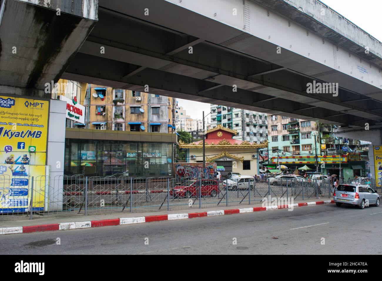 Eine Überflug-Straßenbrücke, alte Wohngebäude und geparkte Autos in der Stadt Yangon, Burma Stockfoto