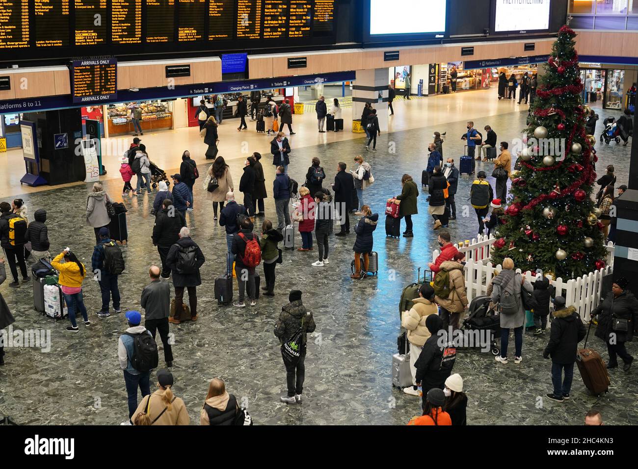 Auf der Bahnhofsanlage am Bahnhof Euston in London warten die Menschen auf ihre Züge. Der erste Weihnachtsurlaub seit zwei Jahren hat in der Weihnachtszeit zu einer hohen Nachfrage nach Freizeitreisen auf der Straße, der Schiene und dem Flugzeug geführt. Bilddatum: Freitag, 24. Dezember 2021. Stockfoto