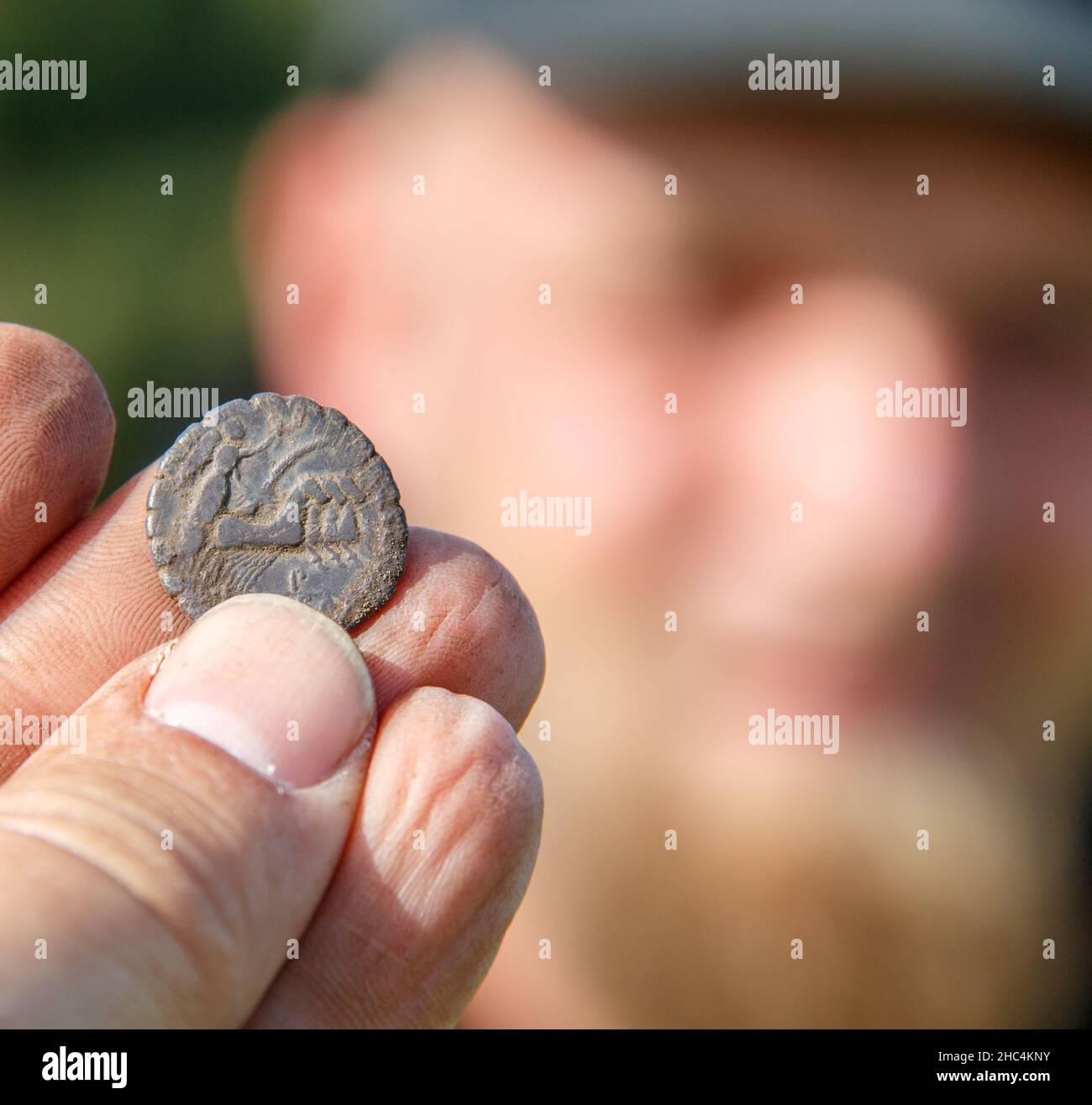 Bronzezeit-Pinzette mit einem Metalldetektor gefunden, Finder im Hintergrund Stockfoto