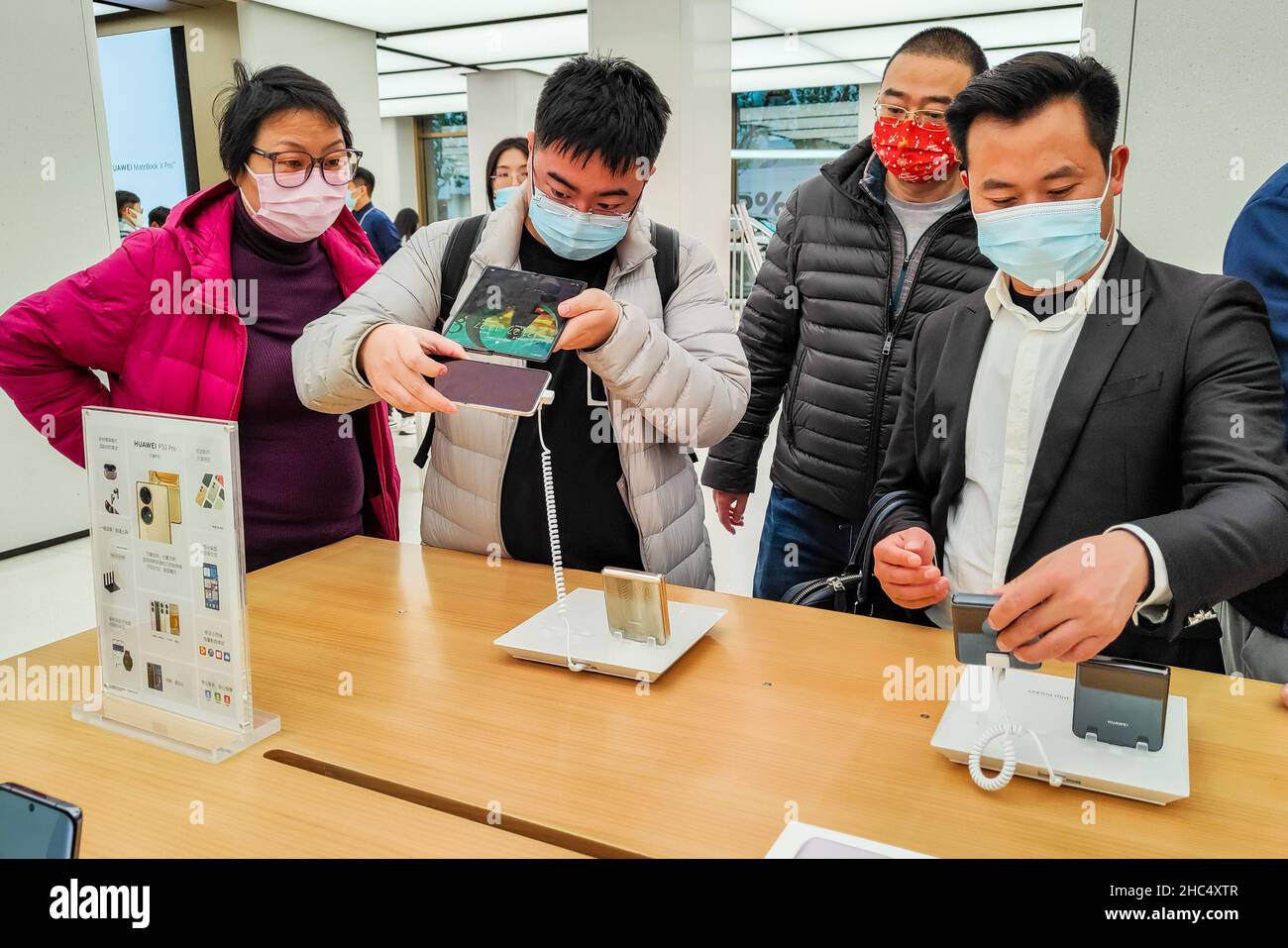 SHANGHAI, CHINA - 24. DEZEMBER 2021 - Kunden testen das neu veröffentlichte faltbare Mobiltelefon P50 Pocket im globalen Flagship-Store von huawei auf Nanji Stockfoto