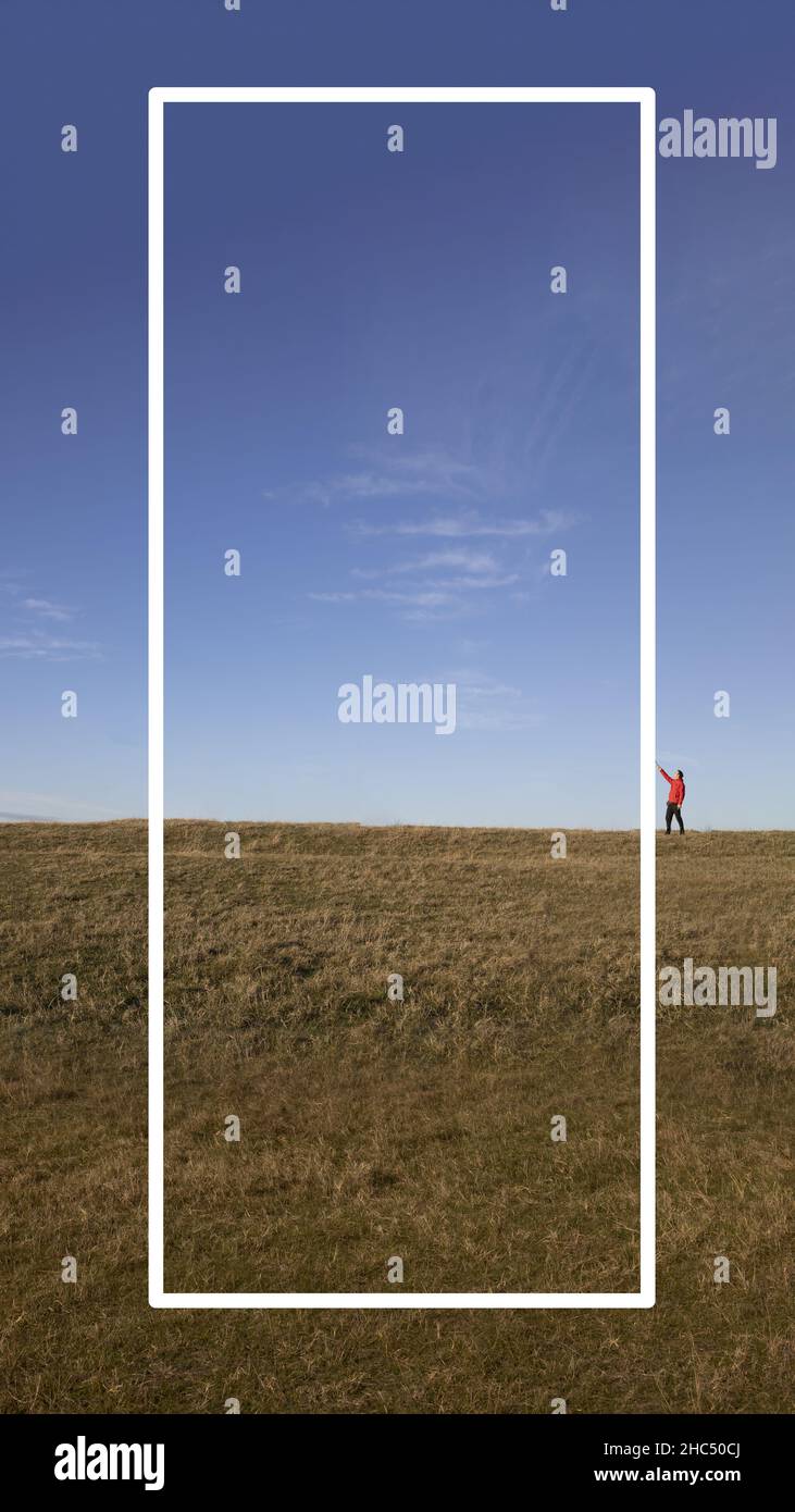 Ein Mann, der ein weißes Textfeld gegen die wunderschöne Landschaft hält. Optimiert für Mobiltelefone Stockfoto