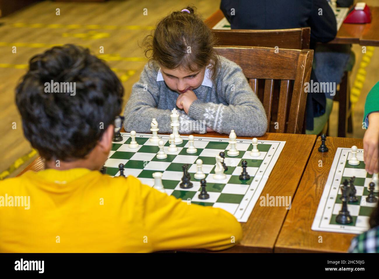 Intelligente Spiele. Ein Kind spielt Schach. Mädchen und ein Schachbrett. Strategie. Logisches Denken. Kleines Mädchen spielt Schach Stockfoto