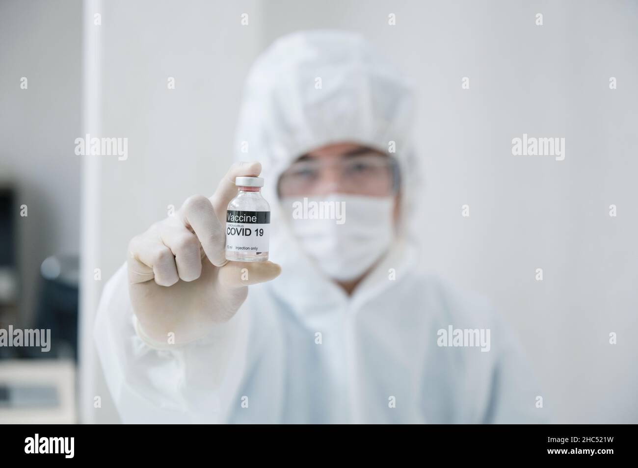 Wissenschaftler Mann in medizinischer schützender psa zeigt im Labor eine wirksame Impfstoffflasche gegen Covid-19, Coronavirus Stockfoto