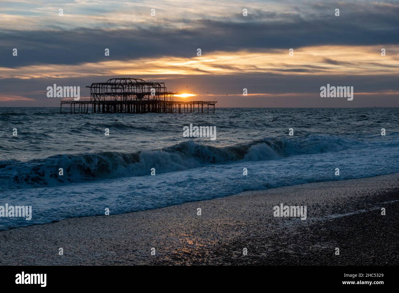 Blick auf den Sonnenuntergang mit Blick auf die Überreste von Brighton's West Pier bei Sonnenuntergang, Brighton, East Sussex, Großbritannien. Stockfoto