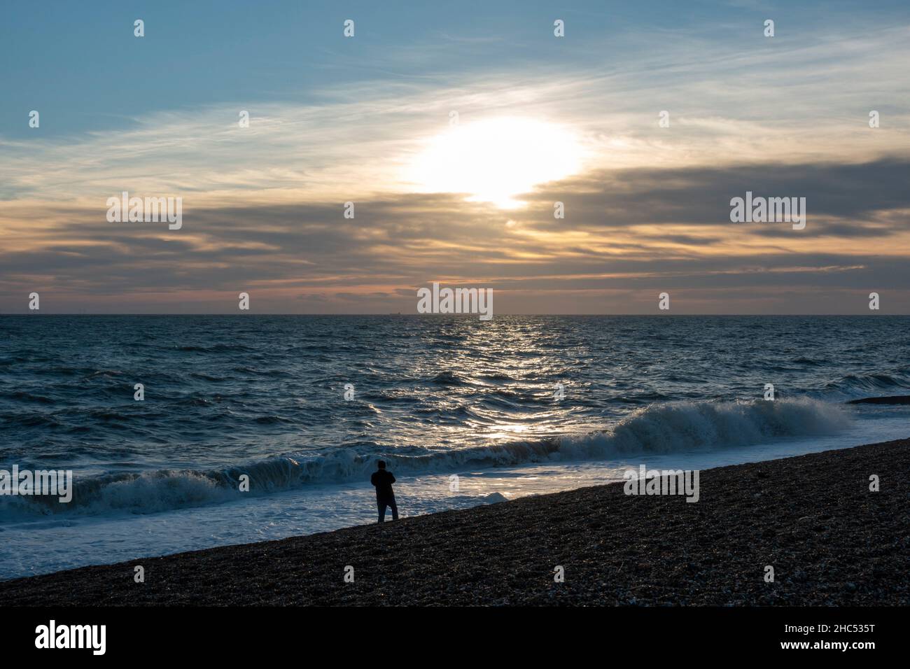 Blick auf den Sonnenuntergang eines Spaziergangs am Strand mit Blick auf die Sonne am Brighton Beach, East Sussex, Großbritannien. Stockfoto