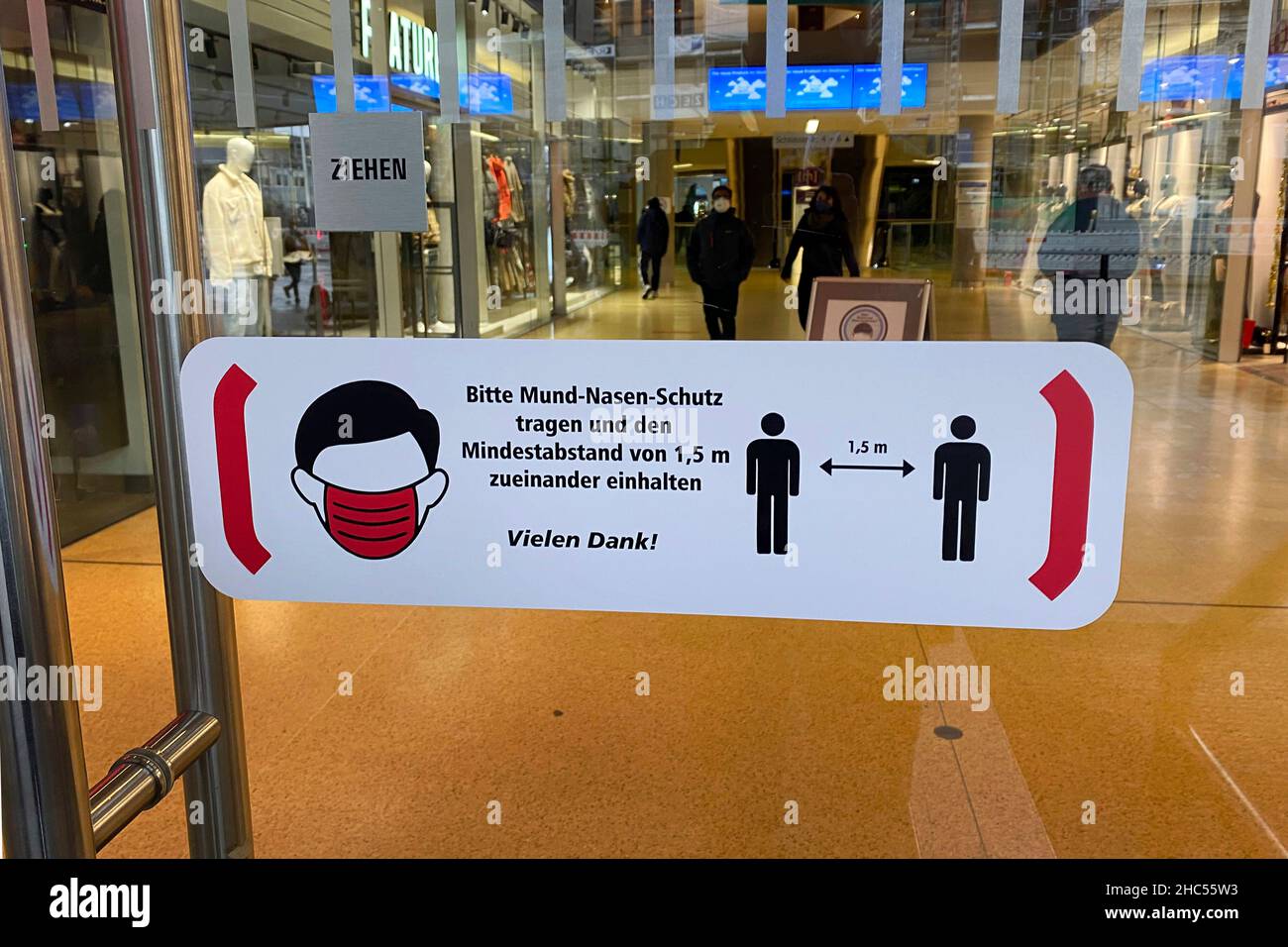 Topic Bild Coronavirus Pandemie, 4th Welle omicron auf dem Vormarsch. SCHILD, STAND BITTE ABSTAND HALTEN, MASKE IST ERFORDERLICH. BEDECKEN SIE MUND UND NASE in einem Einkaufszentrum in München. Hygieneregeln, Entfernungsregeln, Corona-Regeln, Regeln. Stockfoto