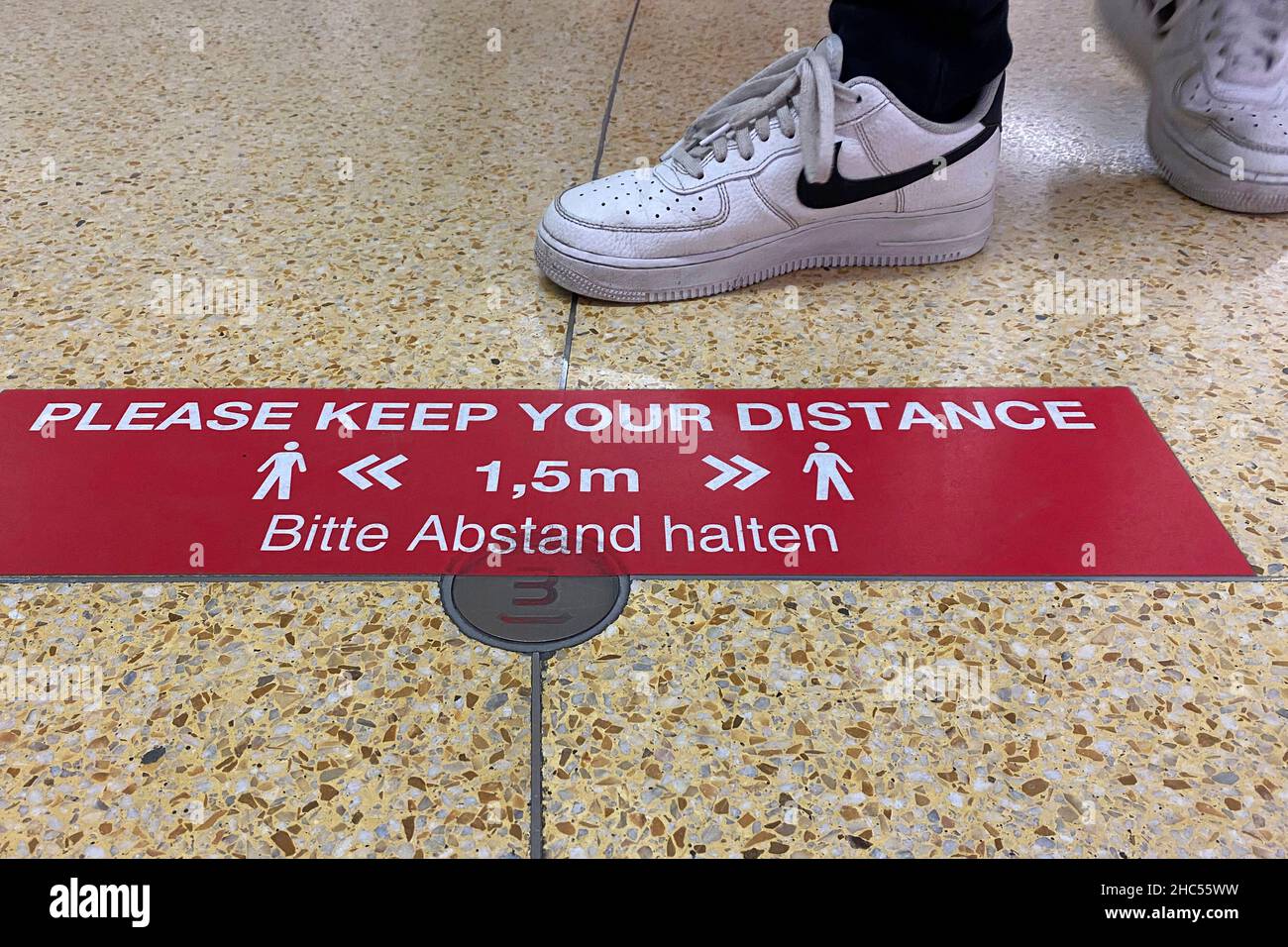 Topic Bild Coronavirus Pandemie, 4th Welle omicron auf dem Vormarsch. Schild, Aufkleber auf dem Boden in einem Einkaufszentrum in München: BITTE ABSTAND halten, DISTANZ HALTEN Hygieneregeln, Entfernungsregeln, Corona-Regeln, Regeln. Stockfoto