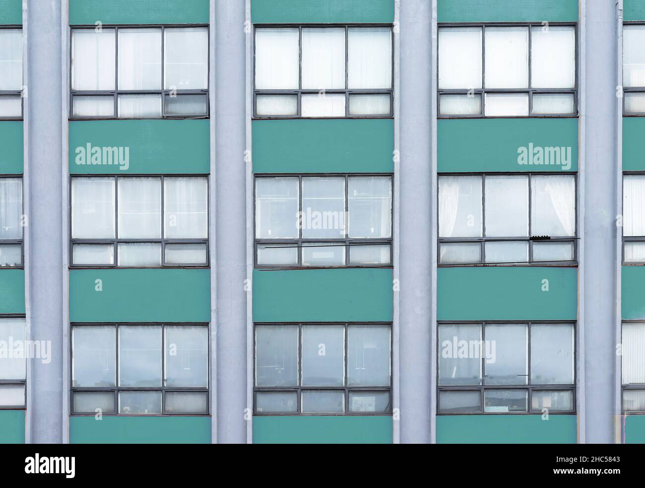 Grünes Architekturgebäude mit Fenstern. Stockfoto