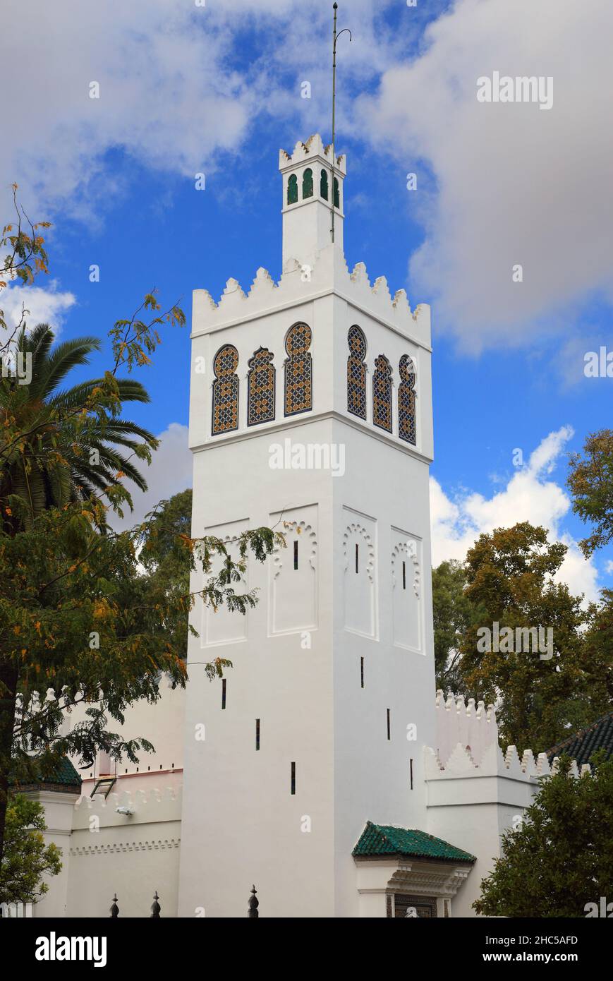 Verschlungenes, altes, weiß getünchtes Minarett und ein wunderschönes Gebäude im Arabeske-Stil in Sevilla, Andalusien, Spanien. Stockfoto