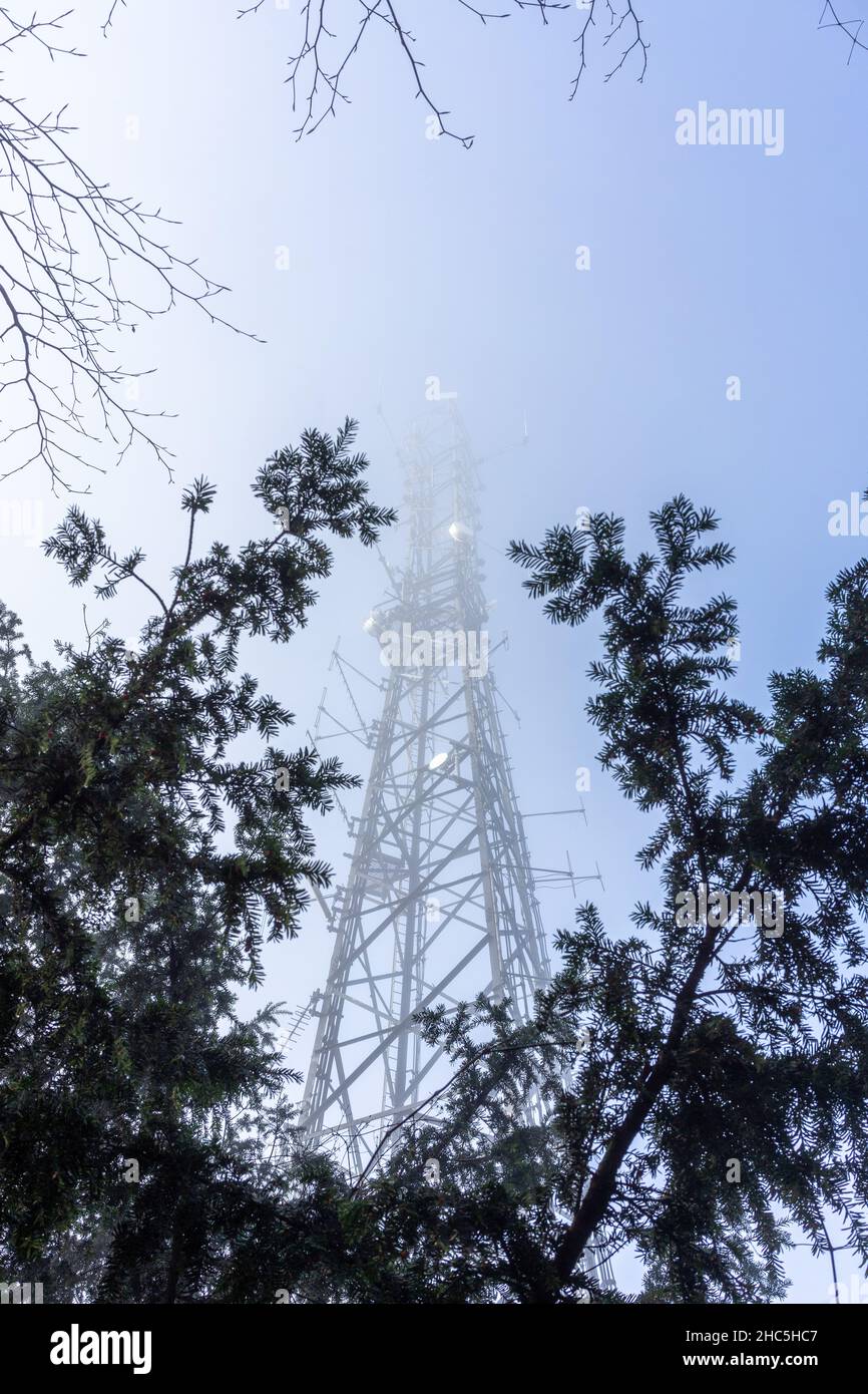 Kommunikationsmast verschwindet im Nebel Stockfoto