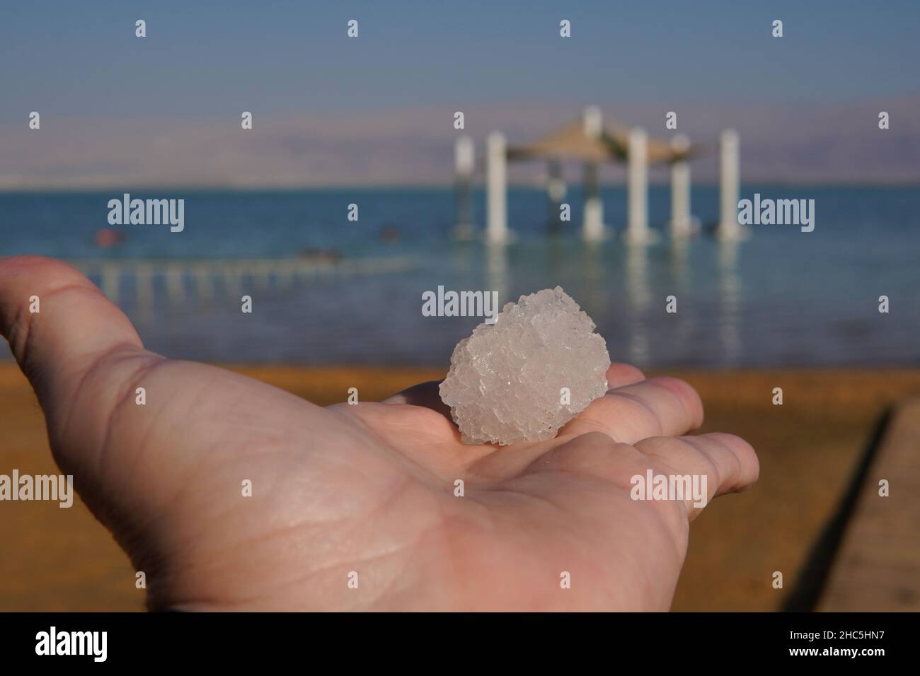 Blick auf das natürliche Salz- und Mineralkristall aus dem Toten Meer auf der Hand Stockfoto