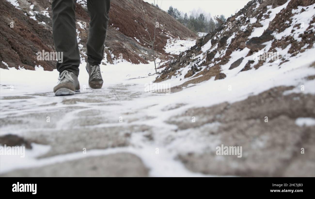 Nahaufnahme von männlichen Beinen in Winterschuhen, die auf Schnee laufen. Blick auf das Wandern auf Schnee mit Schneeschuhen und Schuhspitzen im Winter. Herrenbeine in Stiefeln aus nächster Nähe Stockfoto