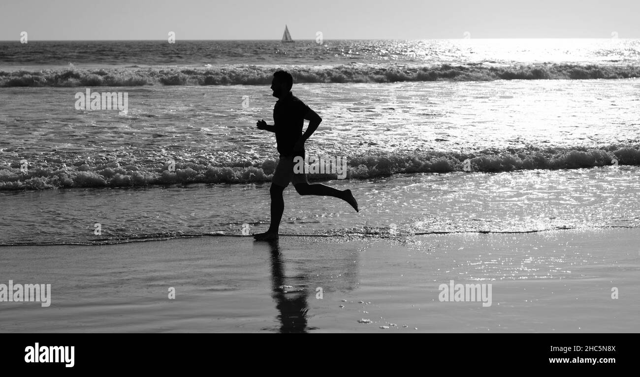 Athletic man Runner Silhouette laufen am Sommerstrand mit Meerwasser und Sonne, Sport Stockfoto