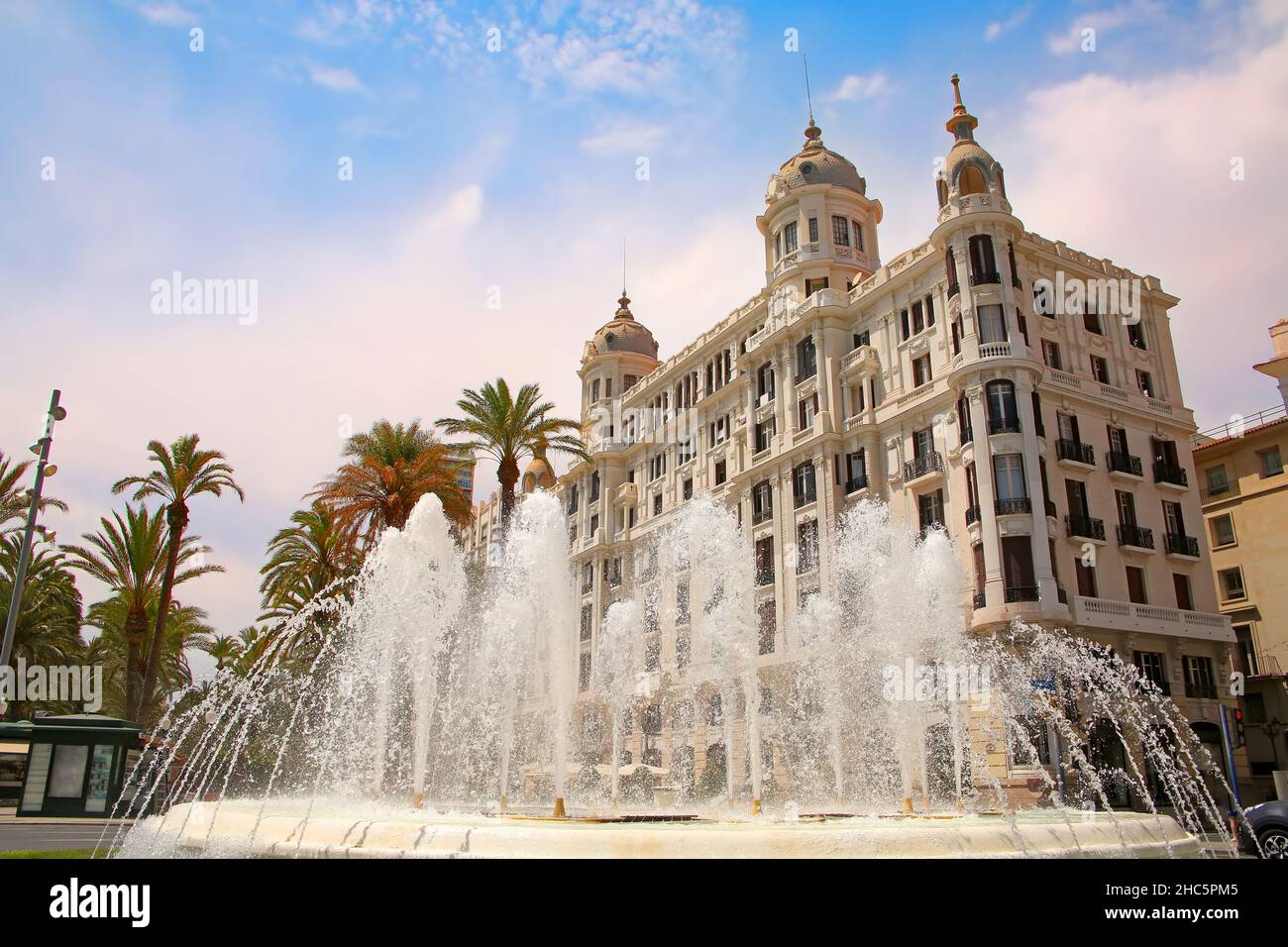 Wunderschöner Springbrunnen entlang der Uferpromenade der Stadt mit historischen traditionellen Gebäuden. Explanada de Espana mit Palmen, Alicante, Spanien. Stockfoto