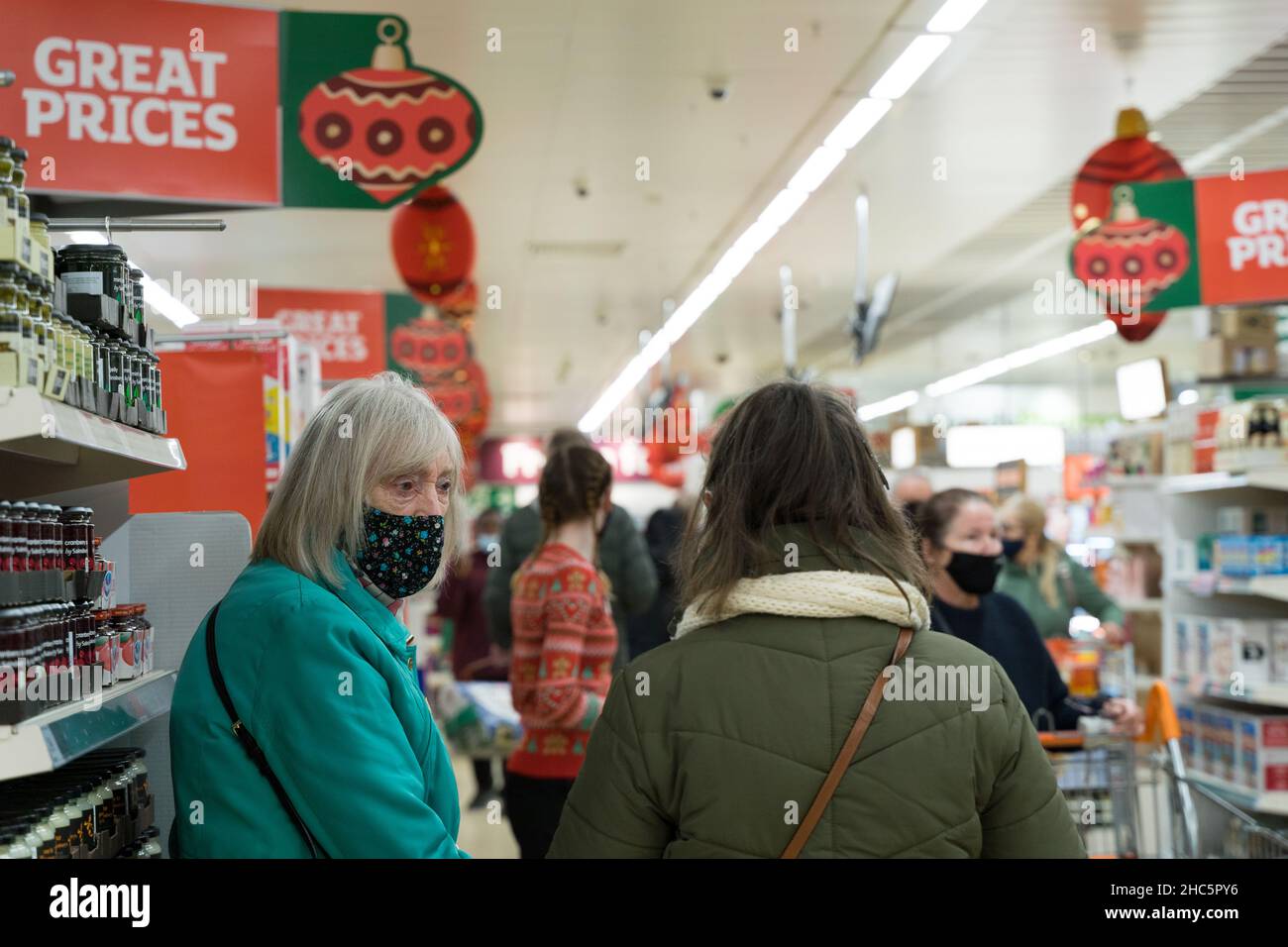 Weihnachtskäufer, die Gesichtsmasken tragen, um zu verhindern, dass sich die omicron-Variante des Coronavirus in der Zeit der Weihnachtszeit im Winter mont ausbreitet Stockfoto
