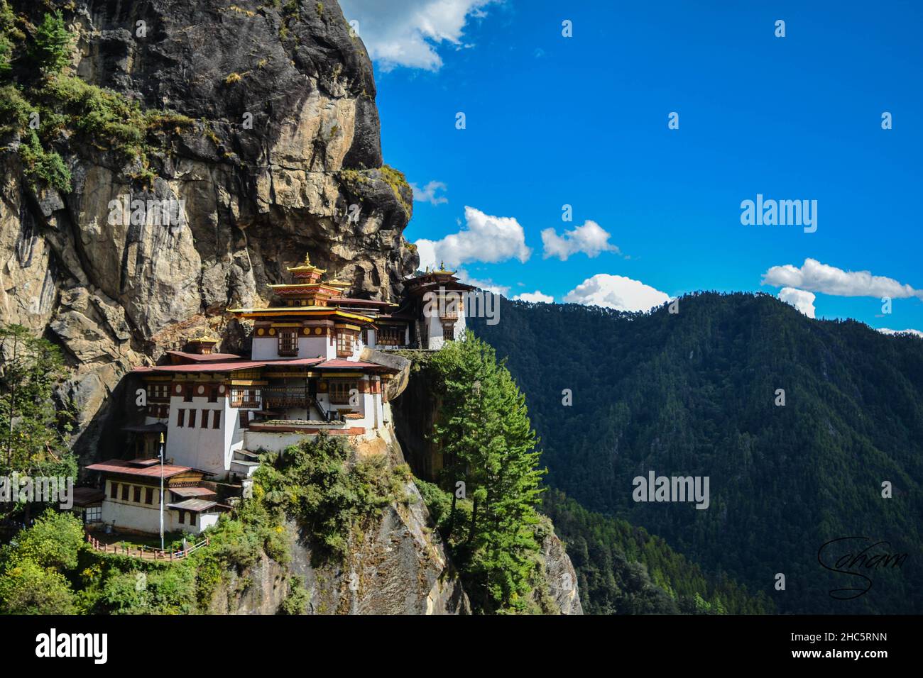 Heller Sommertag im Taktsang Palphug Kloster in Paro, Bhutan mit viel Grün überall Stockfoto