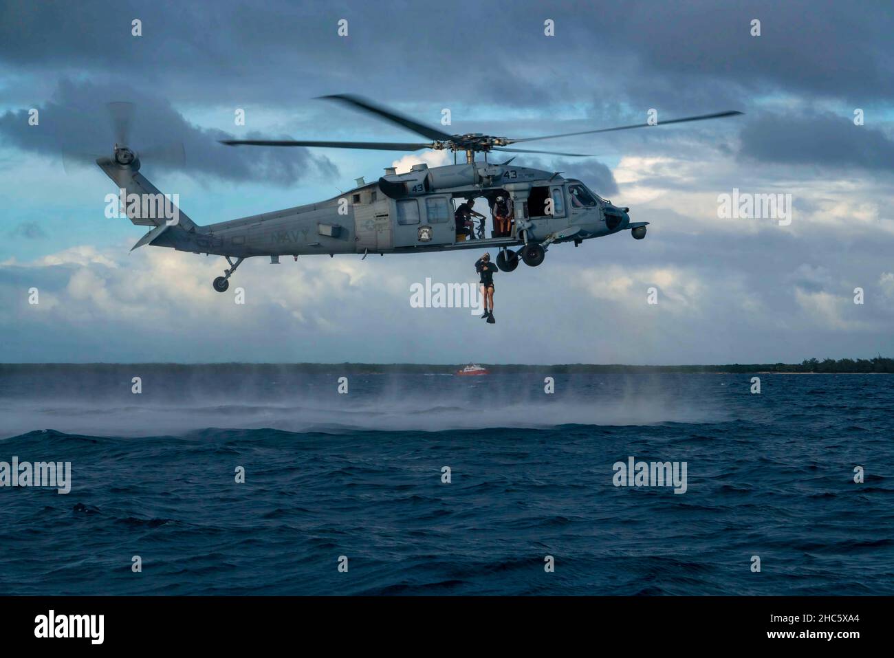 Guam. 13th Dez 2021. Naval Aircrewman (Helicopter) 3rd Klasse Jake Puckett aus Harlingen, Texas, zugewiesen zu den Wildcards von Helicopter Sea Combat Squadron (HSC) 23, springt während einer Freiwasser-Such- und Rettungsübung (SAREX) aus einem MH-60s Sea Hawk Hubschrauber heraus. HSC-23 und USS Jackson (LCS 6), Teil von Destroyer Squadron (DESRON) 7, befinden sich im Einsatzgebiet der US-Flotte 7th im Rotationseinsatz, um die Interoperabilität mit Partnern zu verbessern und als einsatzbereite Kraft zur Unterstützung einer freien und offenen Region im Indo-Pazifik-Raum zu fungieren. (Bild: © U.S. Navy/ZUMA Press Wire Service/ZUMA Stockfoto