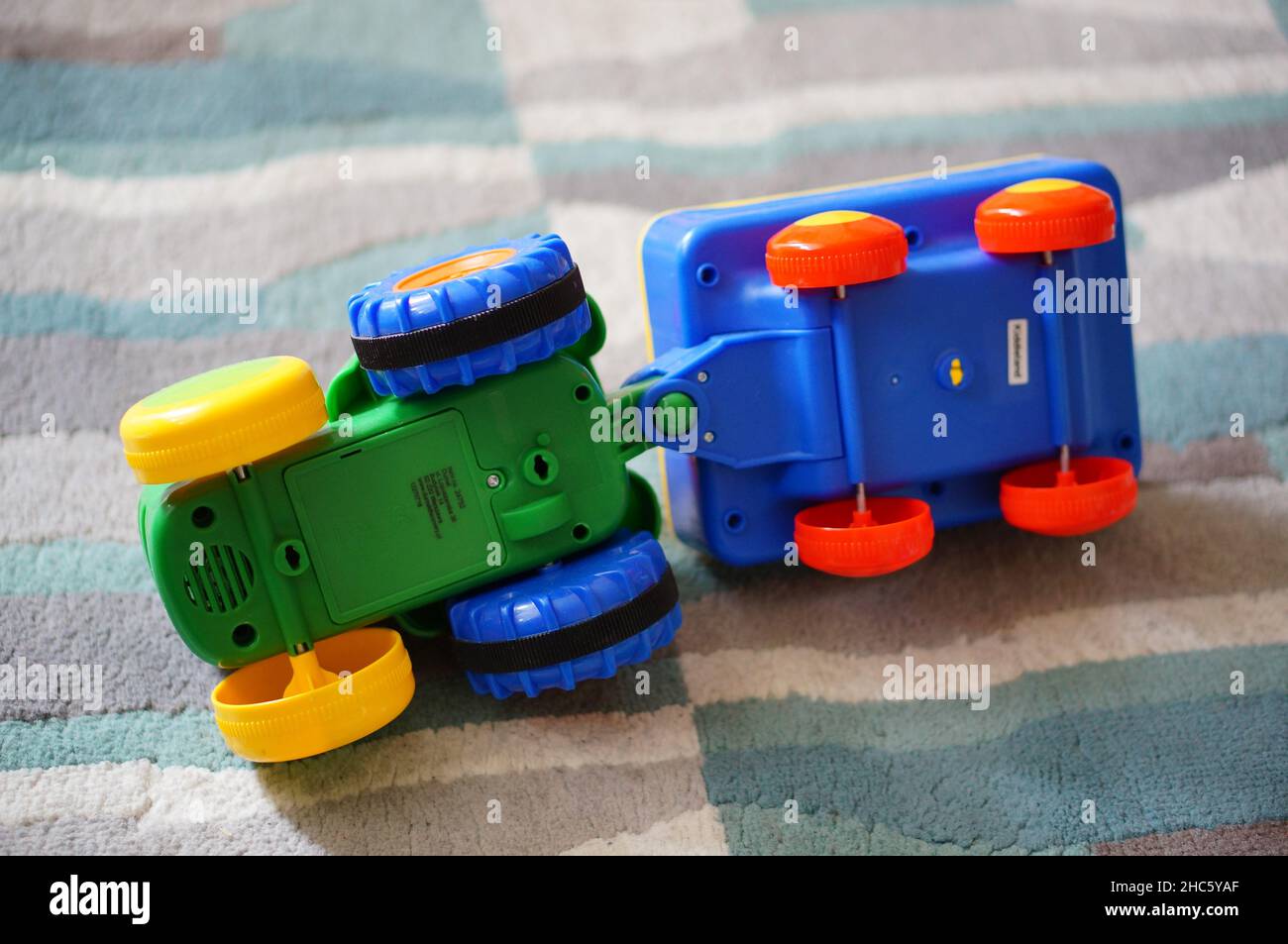Plastik-Traktor-Spielzeug auf einem Teppichboden Stockfoto