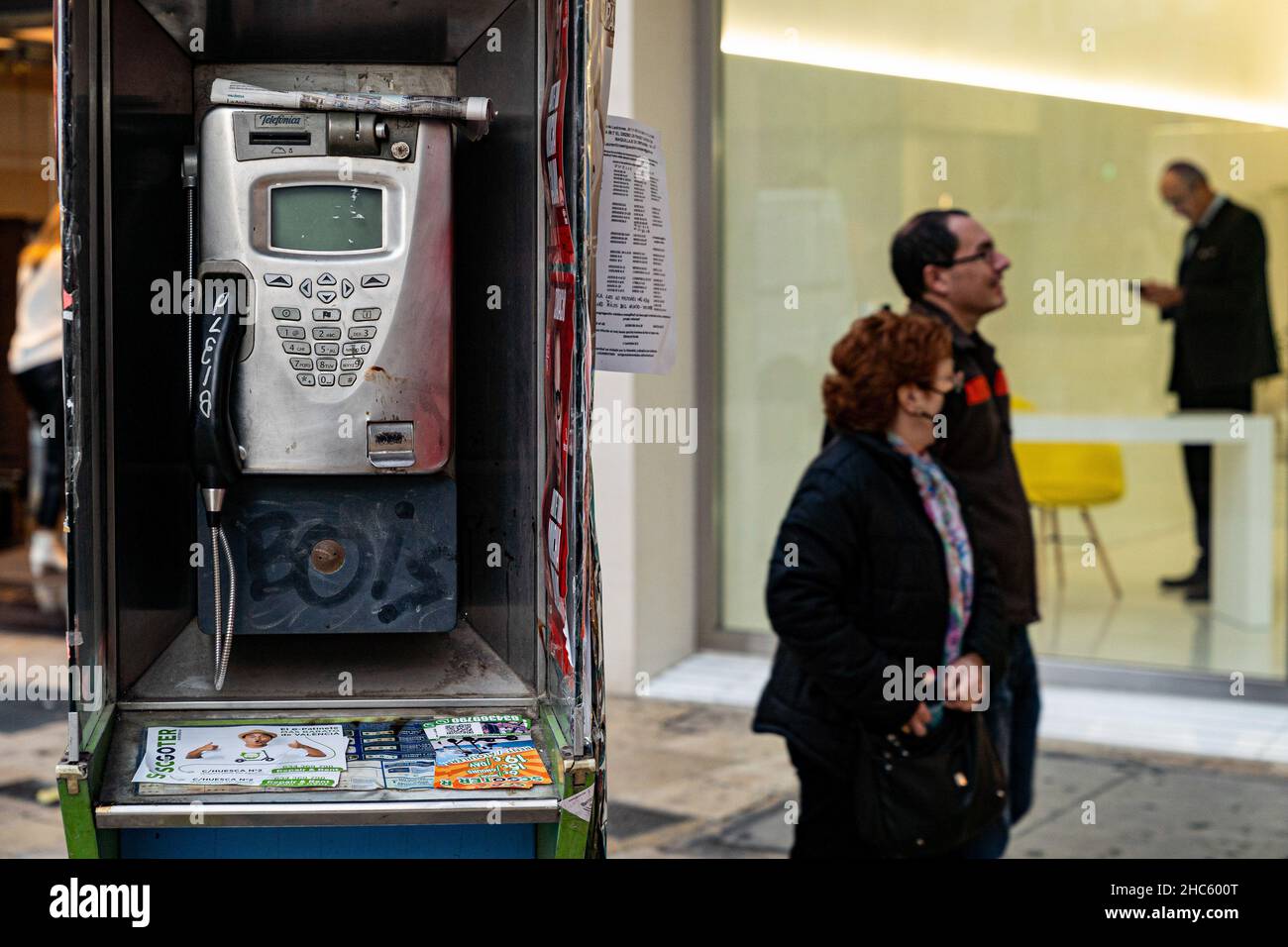 Valencia, Spanien. 15th Dez 2021. In Valencia laufen die Menschen an einer Telefonzelle vorbei.Laut dem neuen Allgemeinen Telekommunikationsgesetz (LGT) werden Telefonzellen 2022 verschwinden. Das Aussehen des Mobiltelefons war die Hauptursache für die Nichtnutzung dieser Kabinen. (Bild: © Xisco Navarro Pardo/SOPA-Bilder über ZUMA Press Wire) Stockfoto